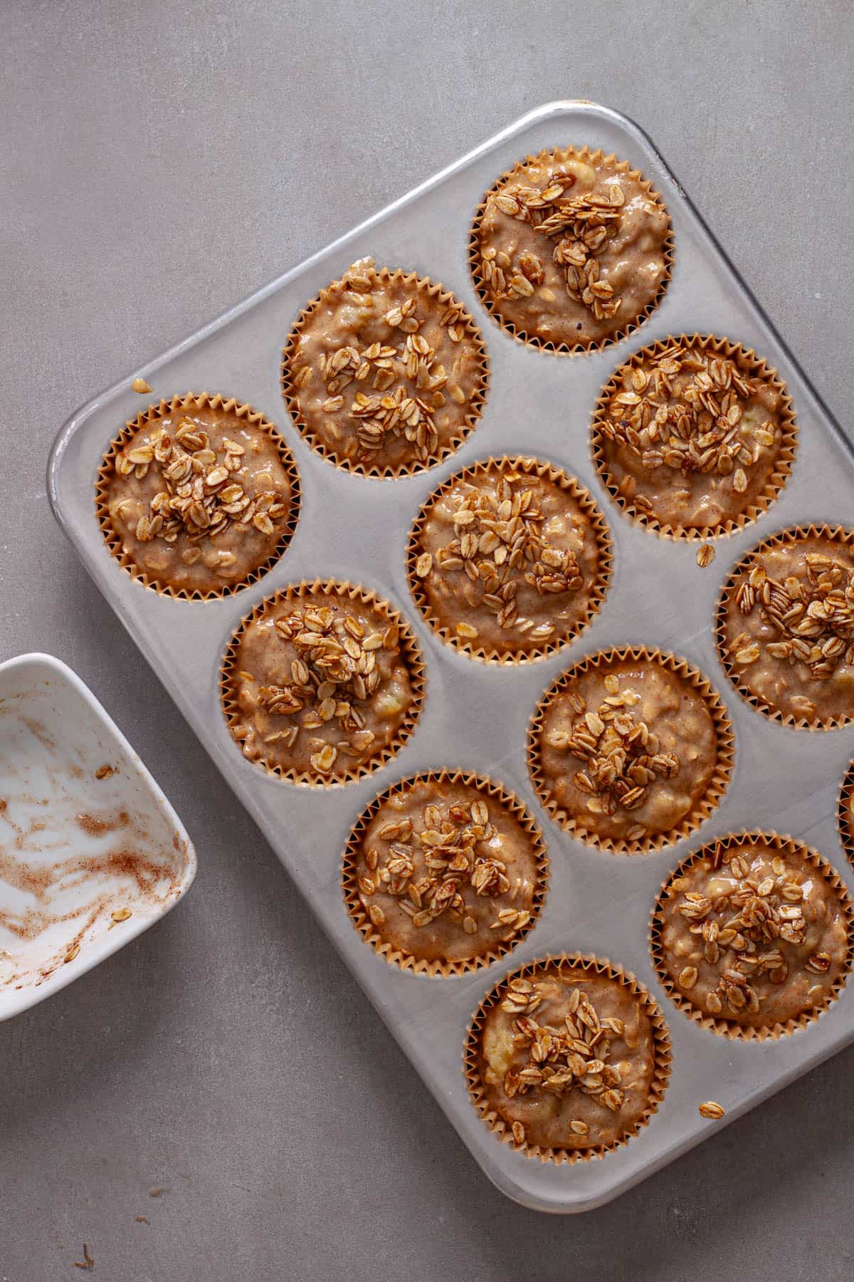A crispy oat topping added to the top of uncooked oat banana muffins.