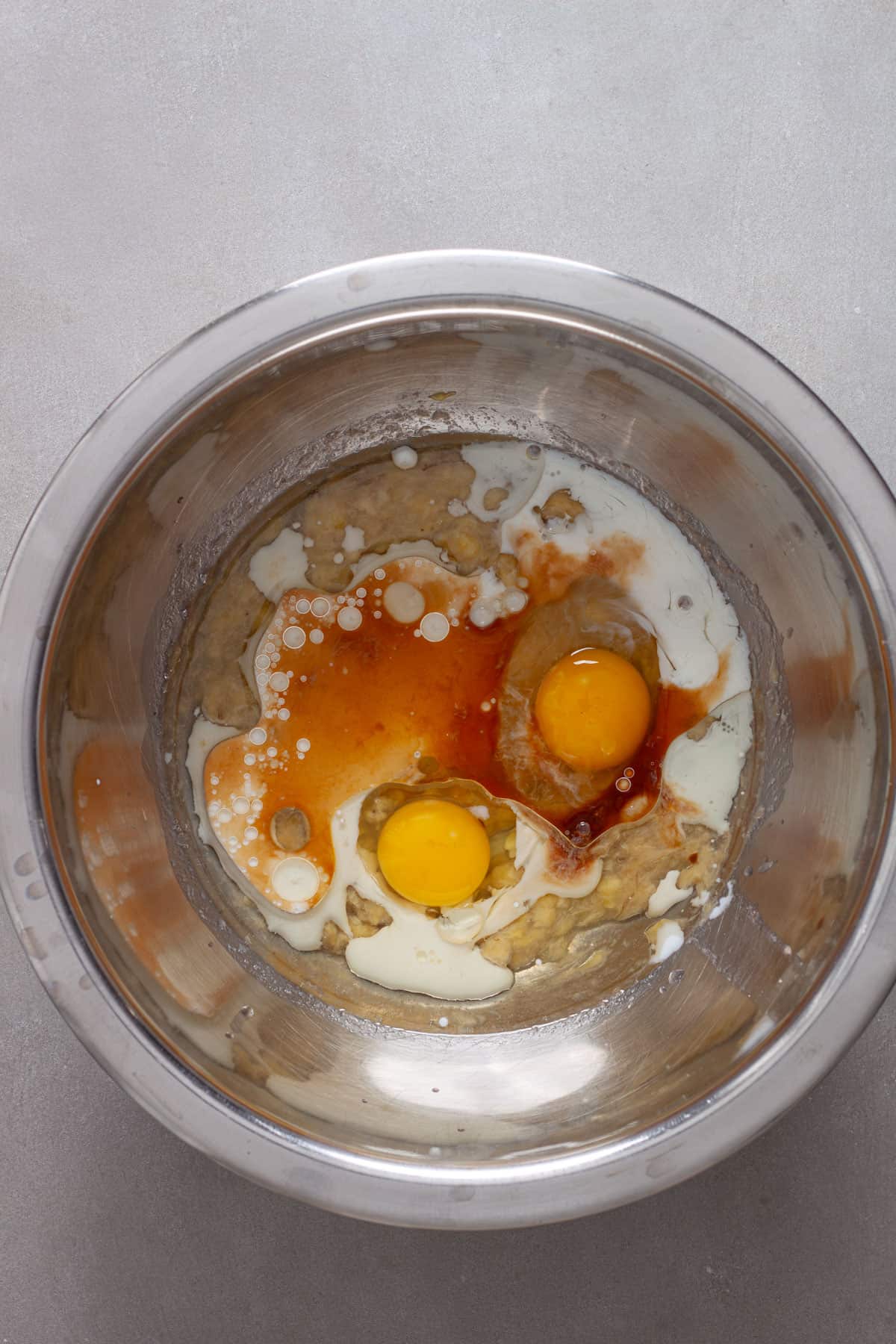 Wet ingredients for oat banana muffins in a mixing bowl.