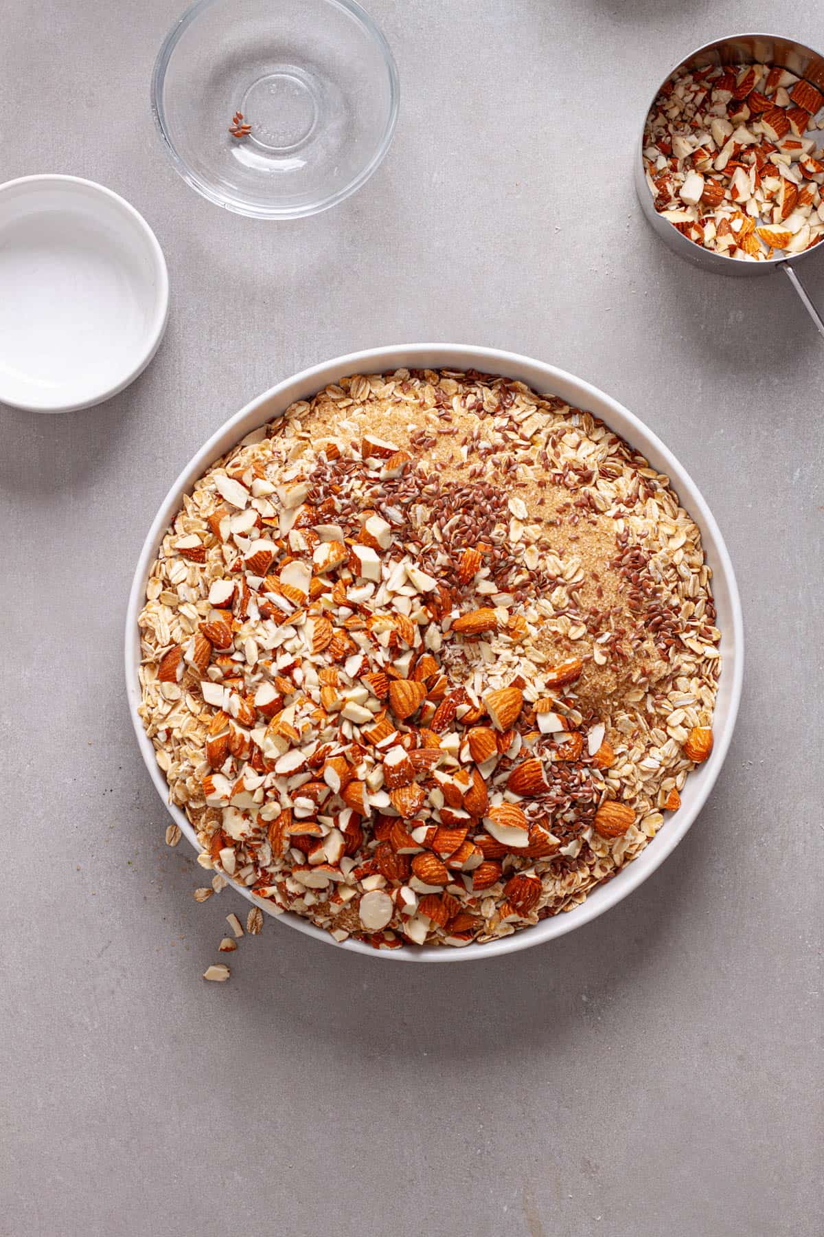 Rolled oats, nuts and brown sugar in a medium mixing bowl.