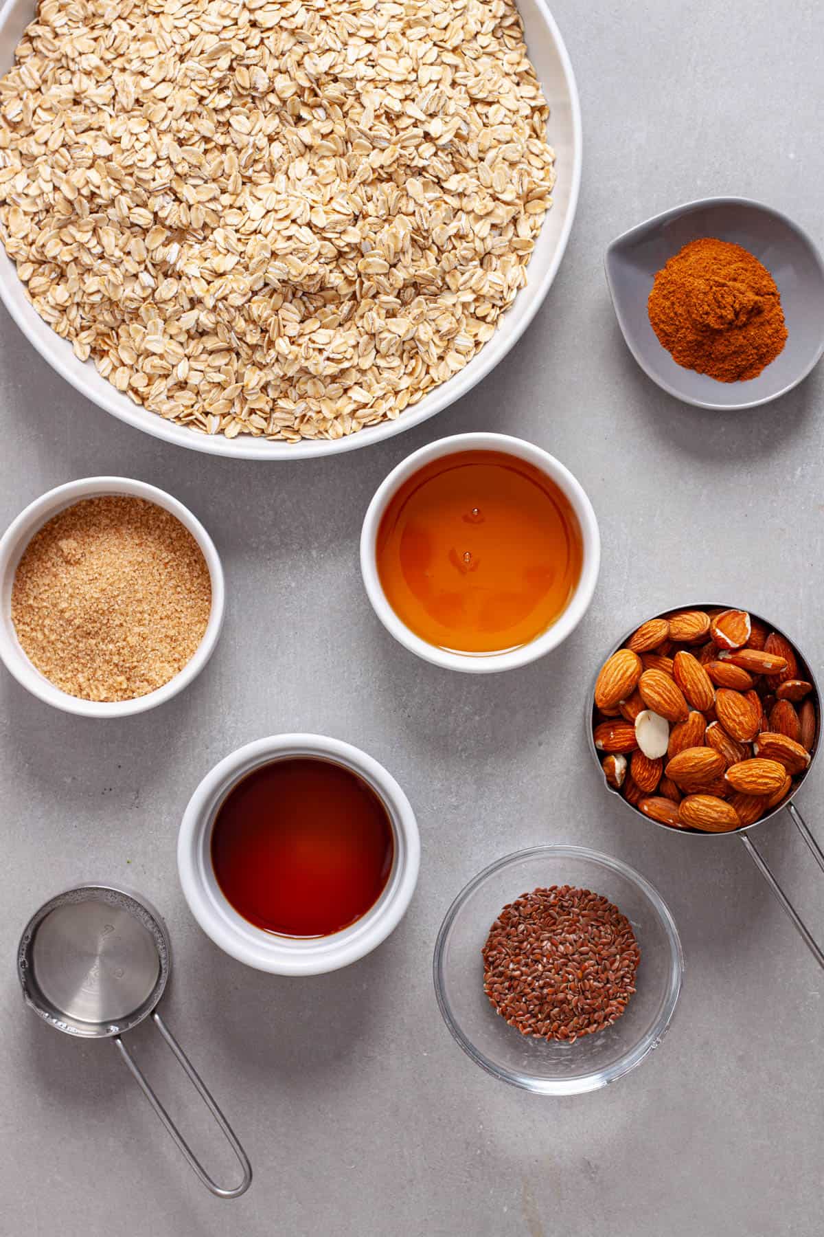 Ingredients for homemade cinnamon granola on a gray table.