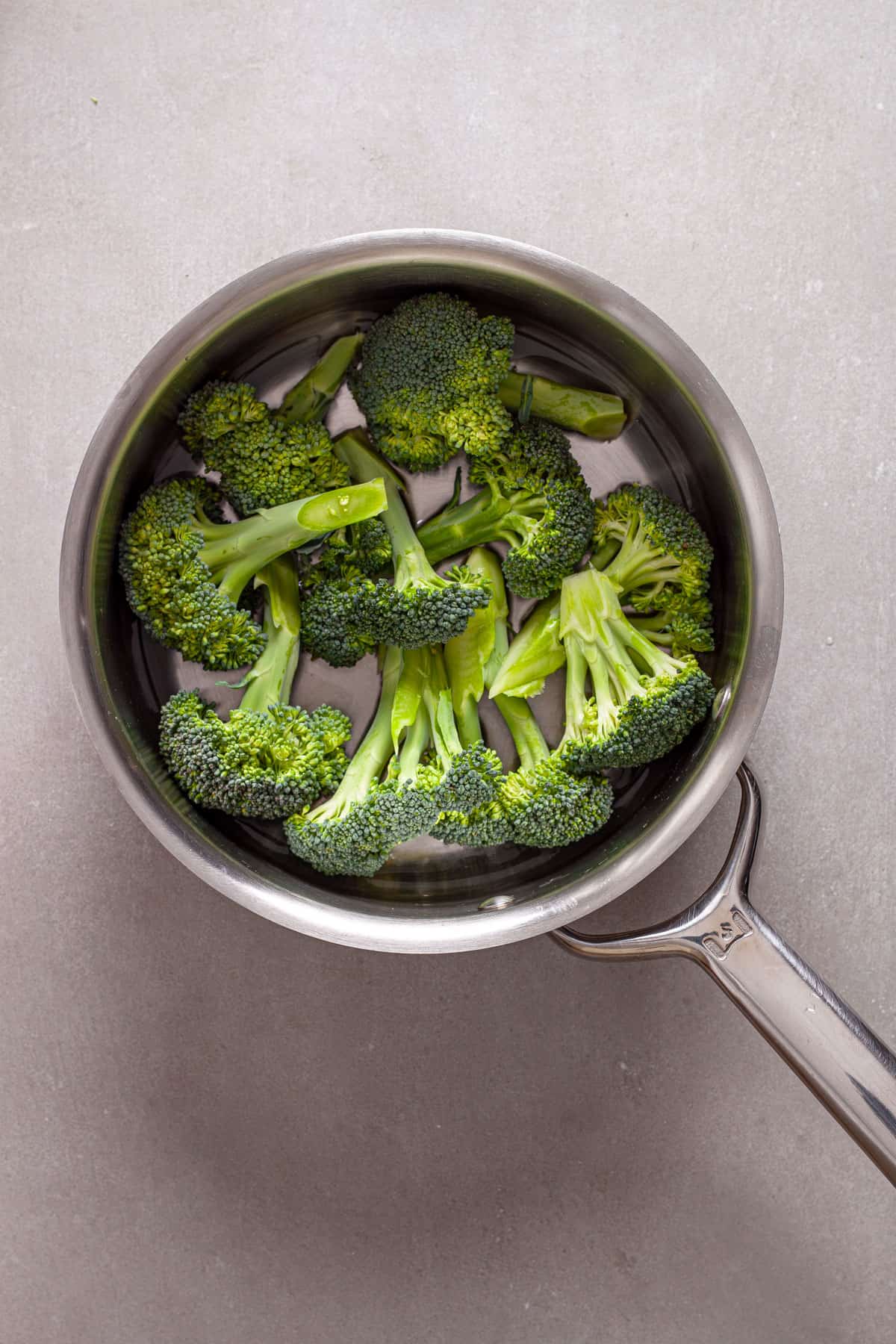 Broccoli florets in a pot ready to get steamed.