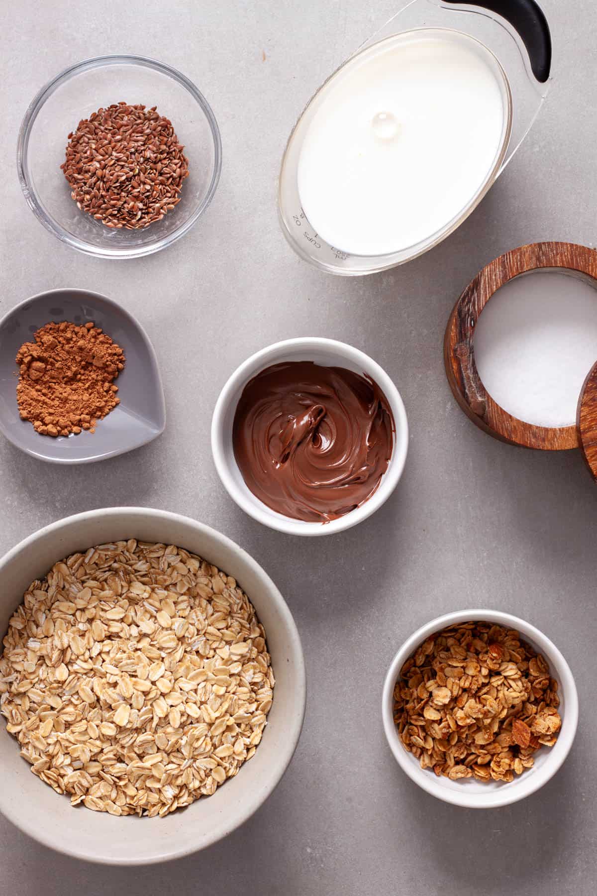 Ingredients for nutella overnight oats on a gray table.