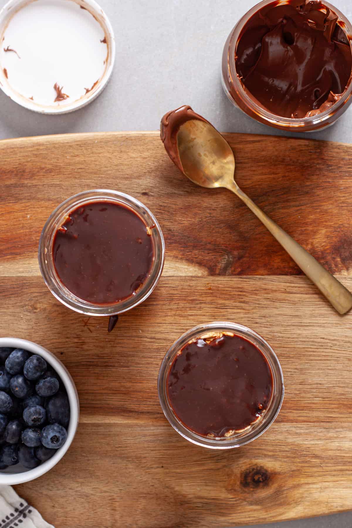 Small mason jars with overnight oats topped with nutella.