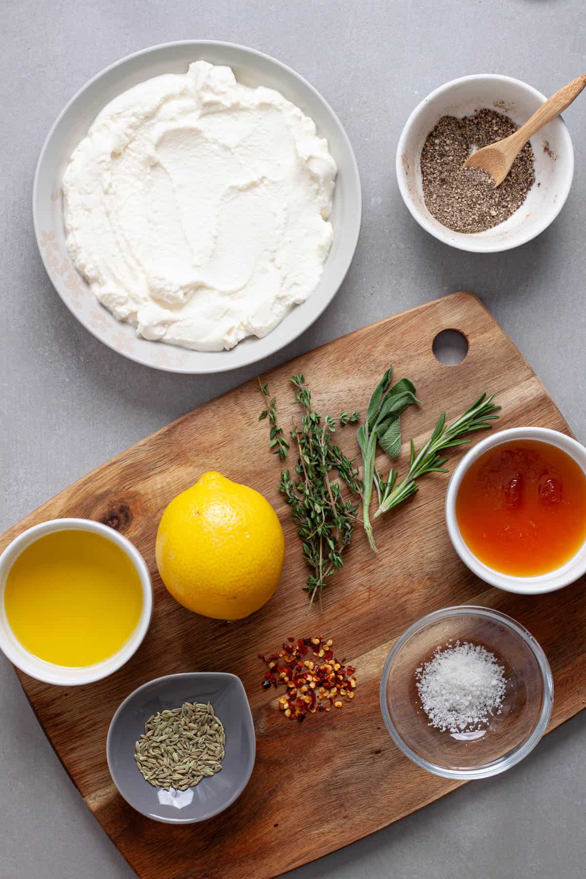 Ingredients for a whipped ricotta cheese dip on a gray table.