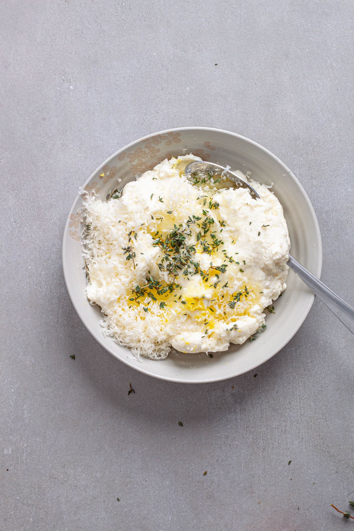 Ricotta cheese with herbs and lemon juice in a small bowl.