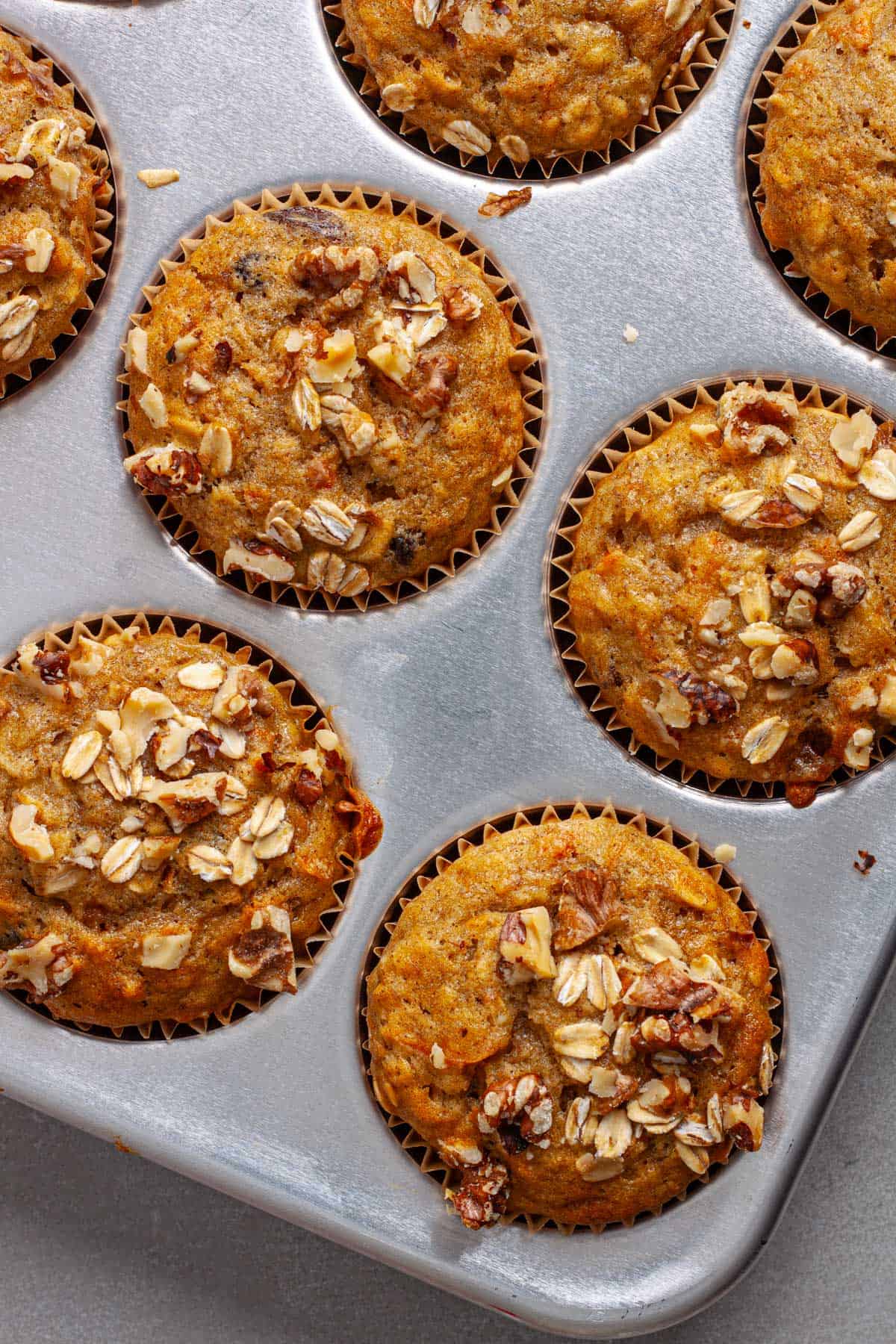 A closeup of banana carrot muffins in a metal muffin tin.