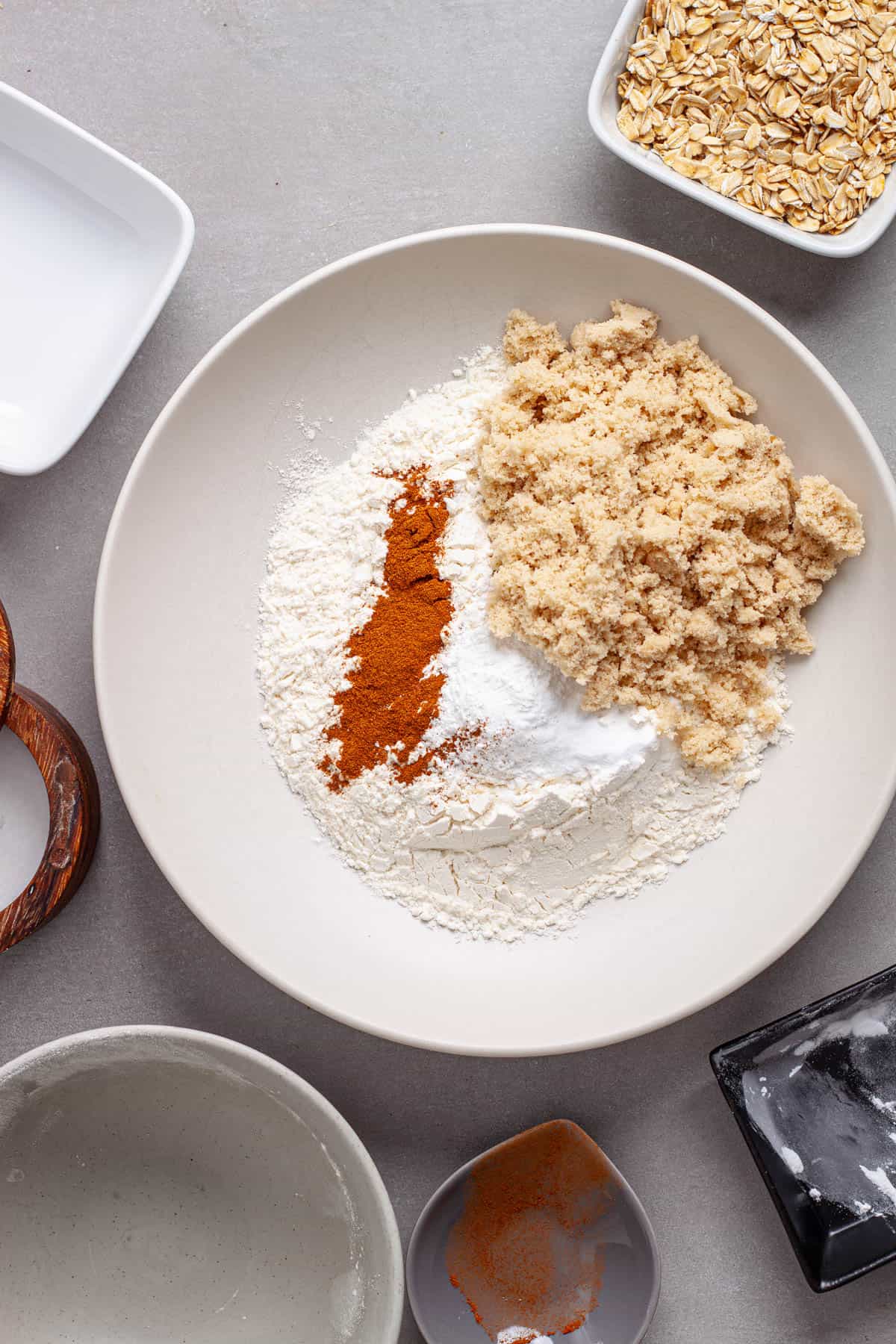 Dry ingredients for carrot and banana muffins added to a mixing bowl.