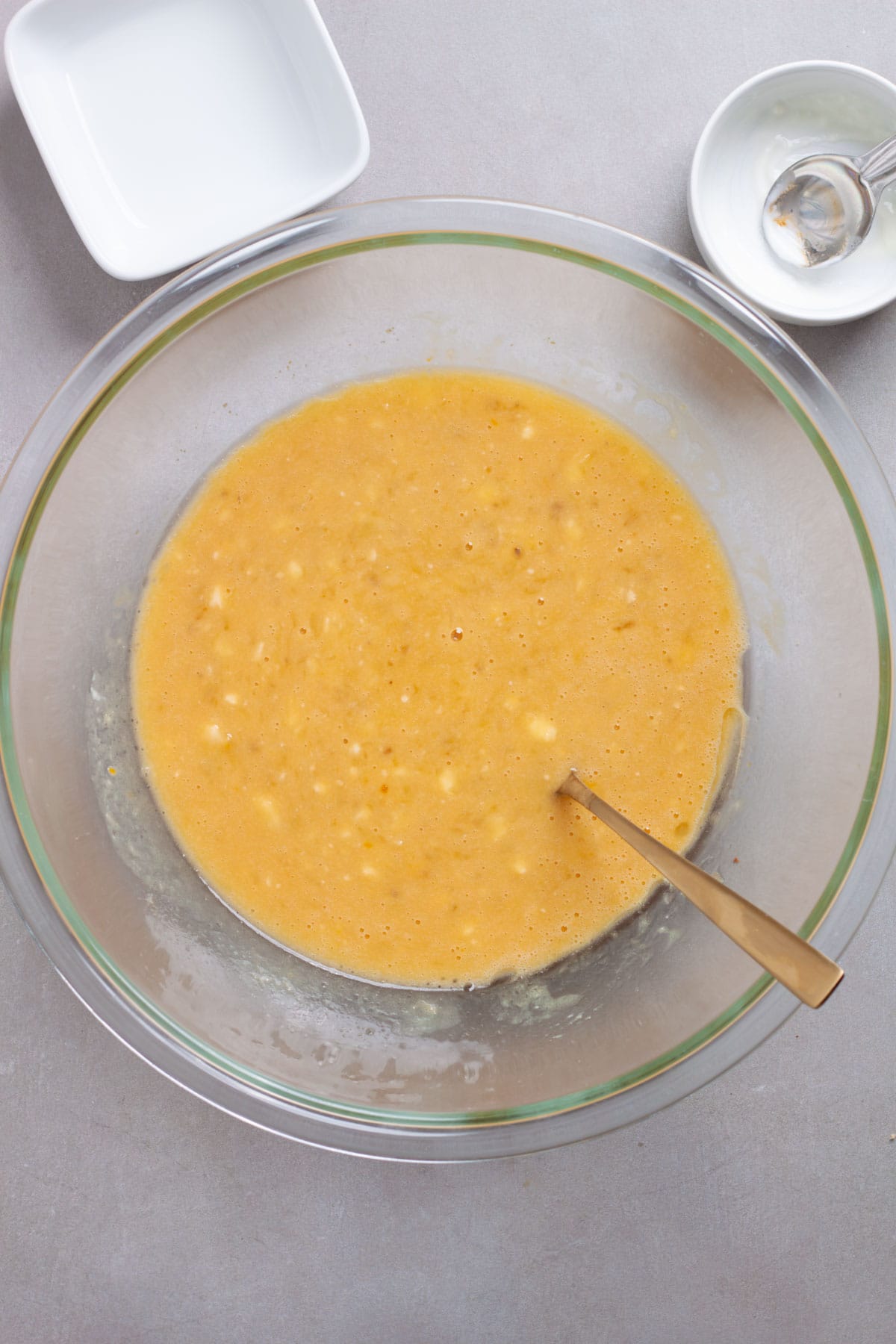 Wet ingredients for banana muffins in a glass bowl.