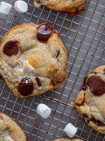 Chocolate chip marshmallow cookies cooling on a wire rack.