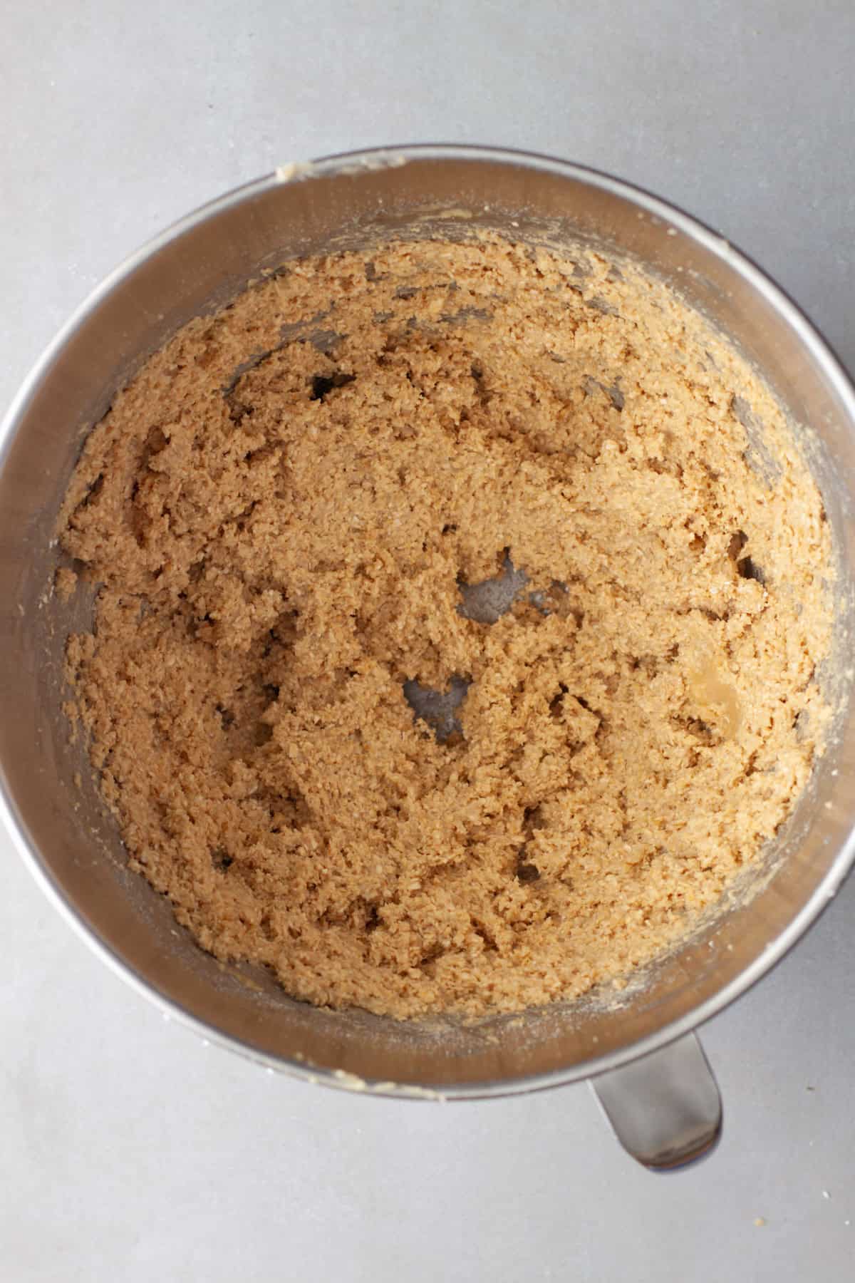 Oat flour cookie base in a medium mixing bowl ready for chocolate chips to be added.