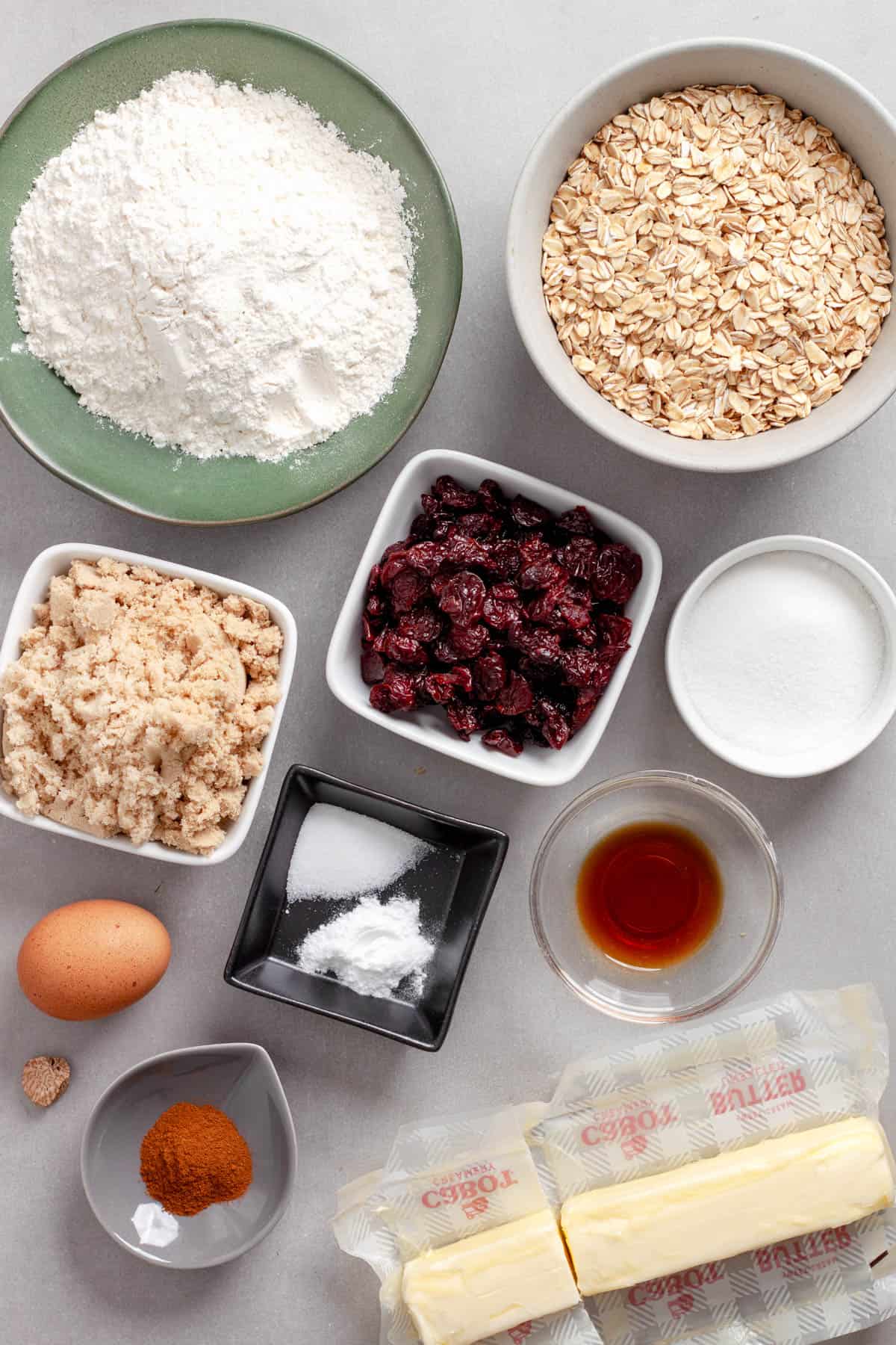 Ingredients for oatmeal cherry cookies on a gray table.