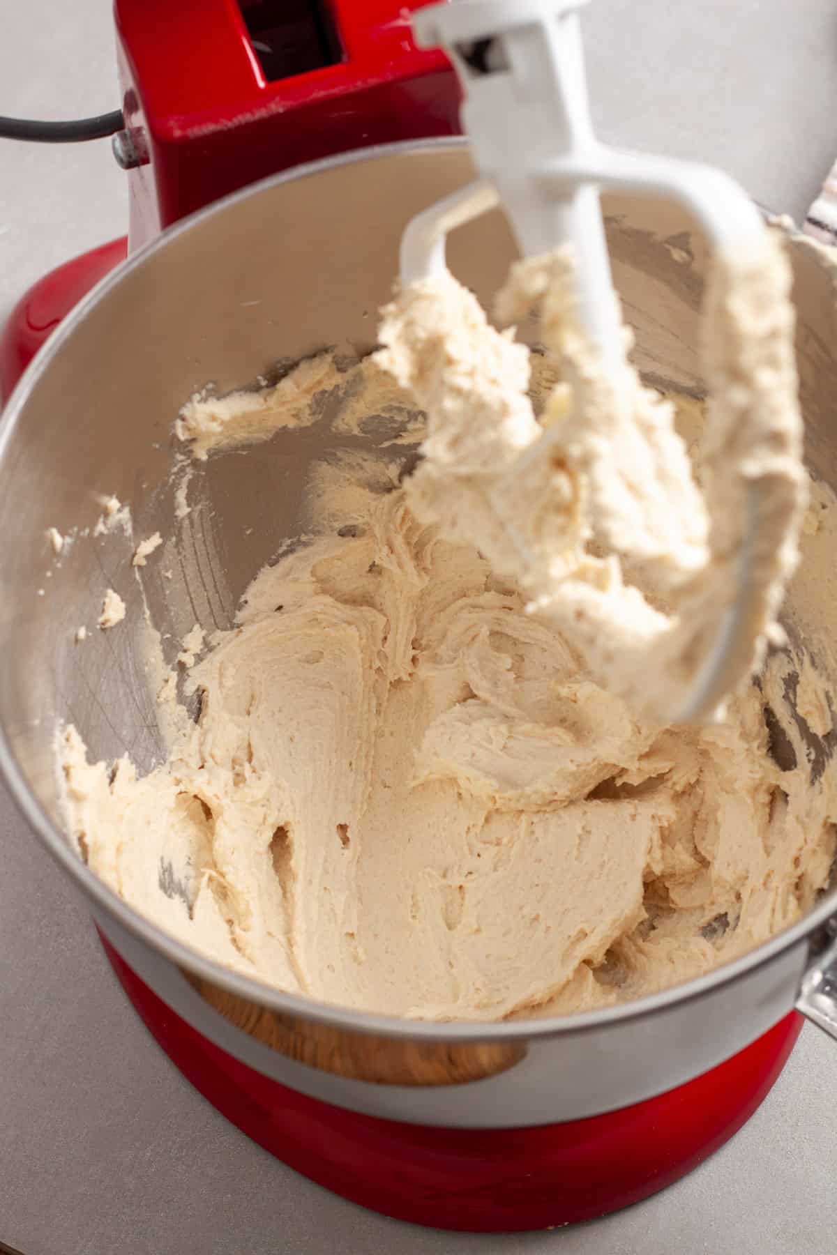 Butter and sugar whipped together in a  red stand mixer. 