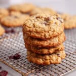 A stack of oatmeal cherry cookies on a wire rack cooling.