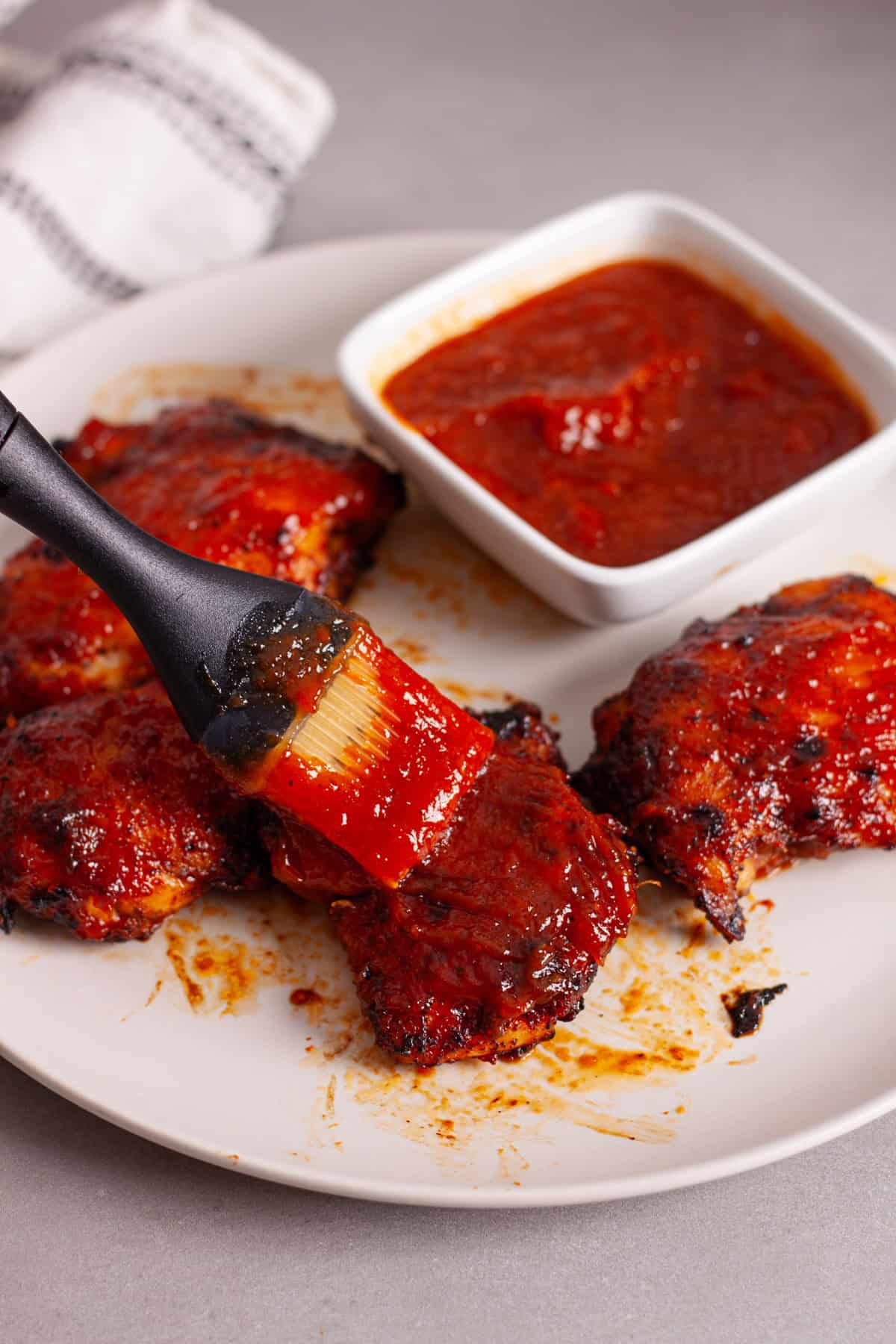 Chicken thighs getting slathered in homemade pineapple bbq sauce.