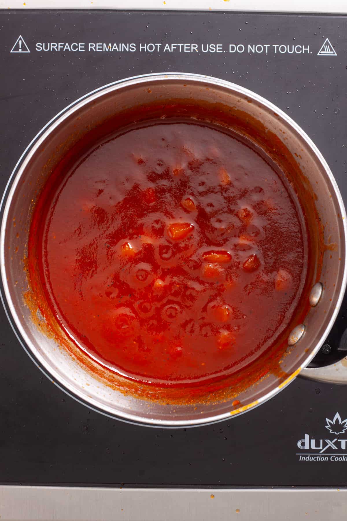 Pineapple bbq sauce in a small saucepan cooking to a thick sauce.