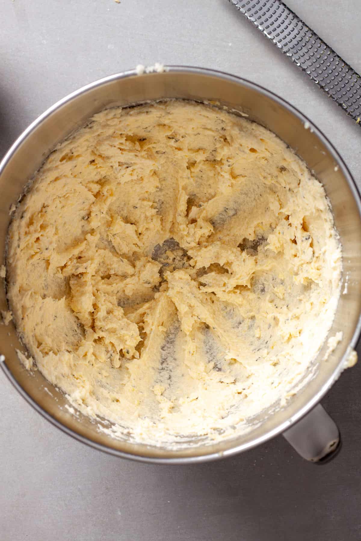 A metal bowl with butter, sugar and lemon zest mixed together food cookies.
