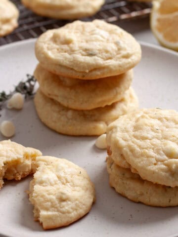 A small stack of lemon and white chocolate chip cookies on a plate.