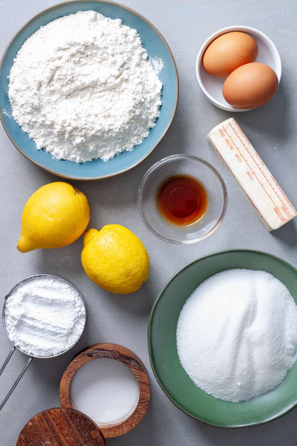 Ingredients for lemon and vanilla blondies on a gray table.
