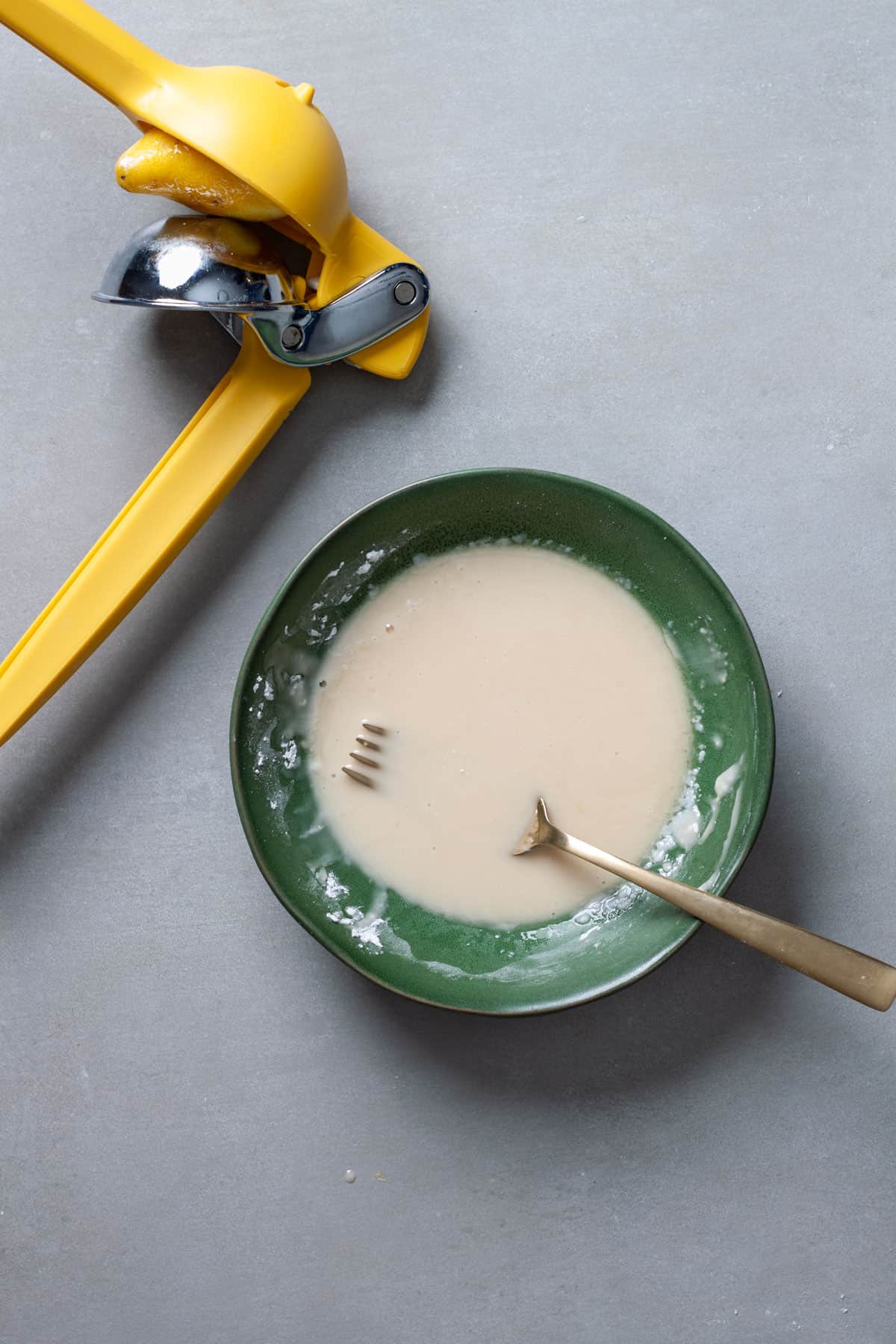 Lemon icing in a green bowl for blondies.