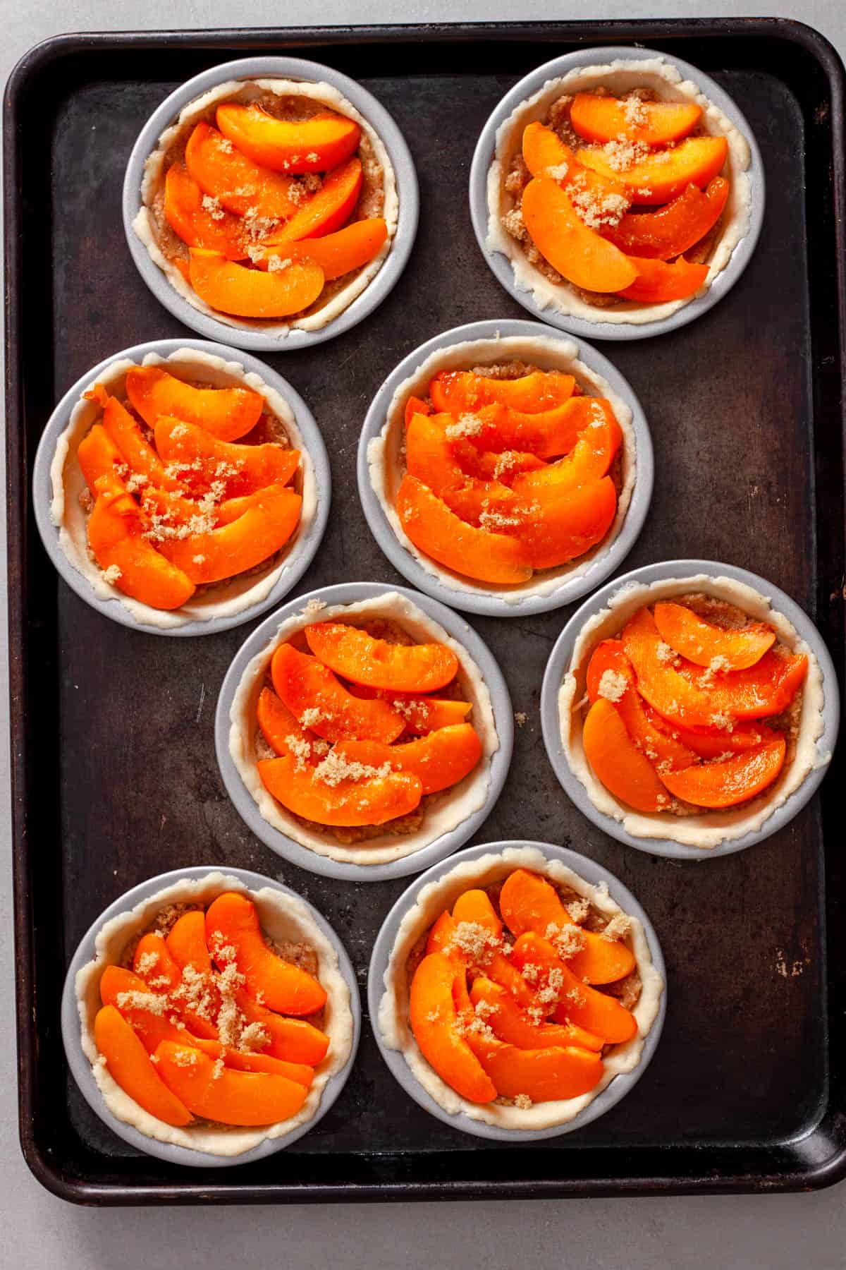 Almond slices added on top of almond filling for mini tarts.