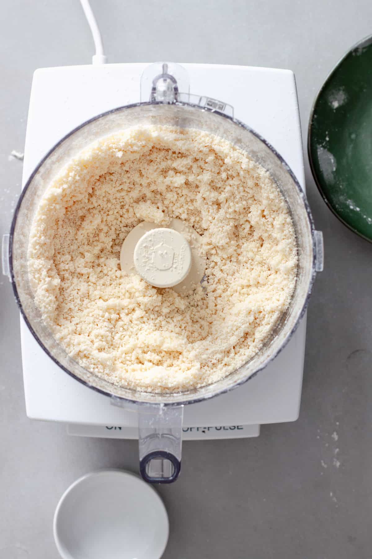 Butter pulsed into a flour mixture in a food processor for a homemade pie dough.