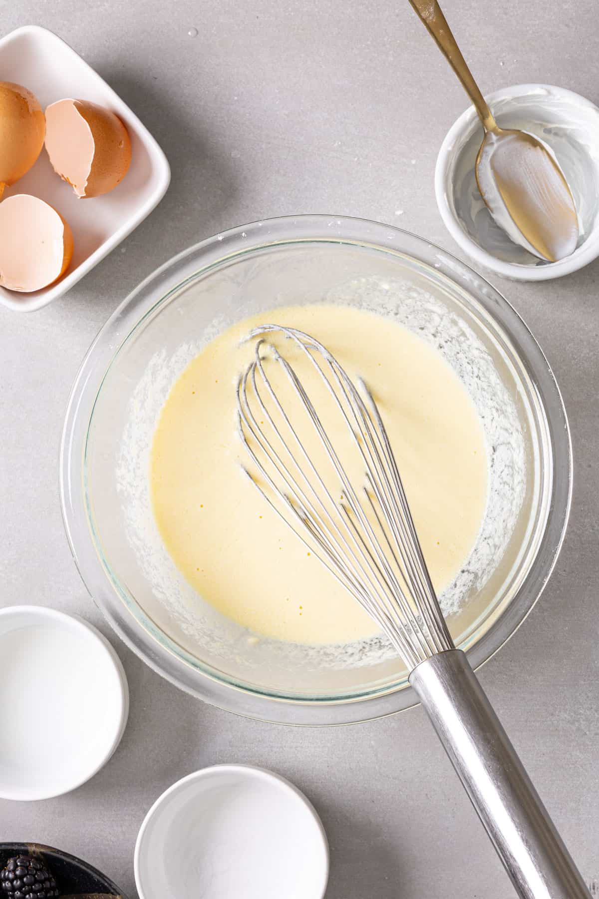 Wet ingredients for muffins in a glass mixing bowl whisked until smooth.