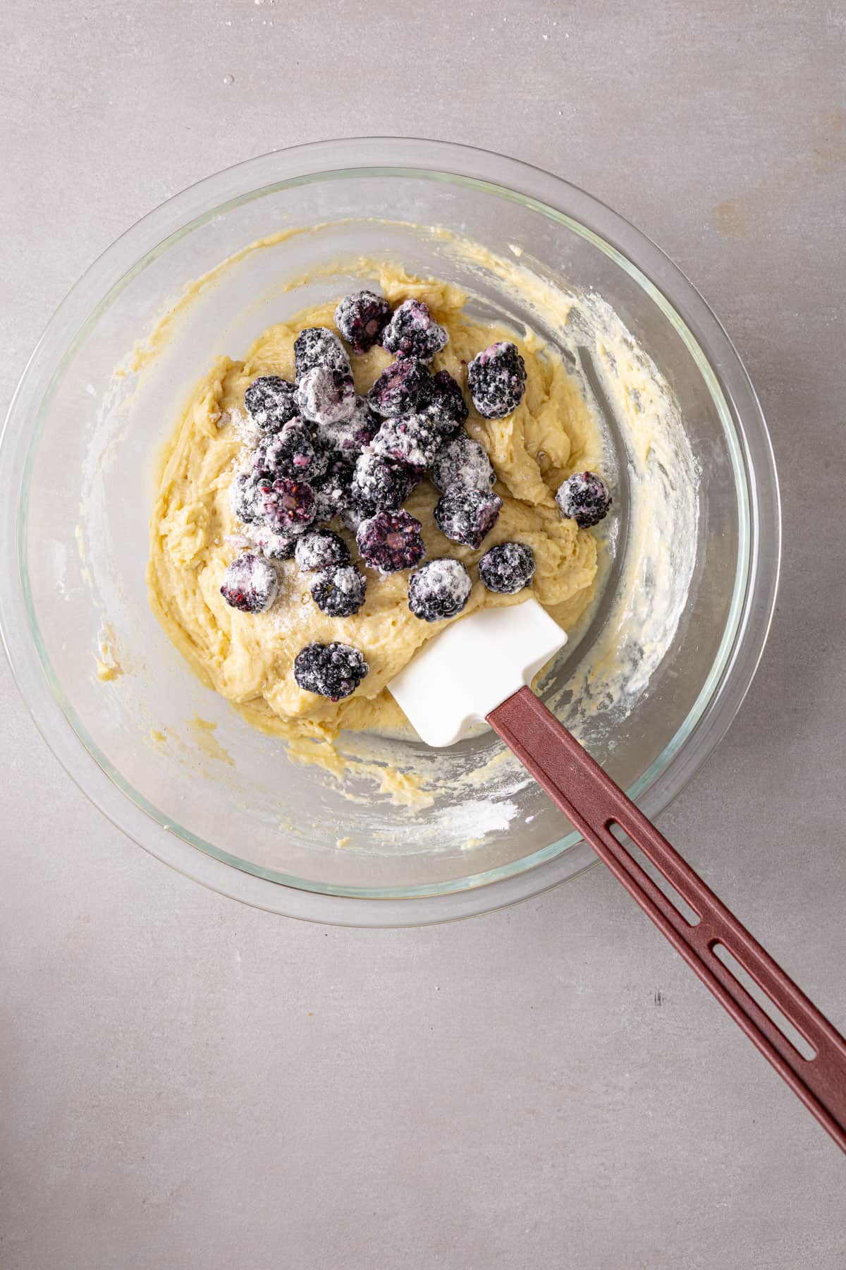 Blackberries coated in a bit of flour mixing into muffin batter.