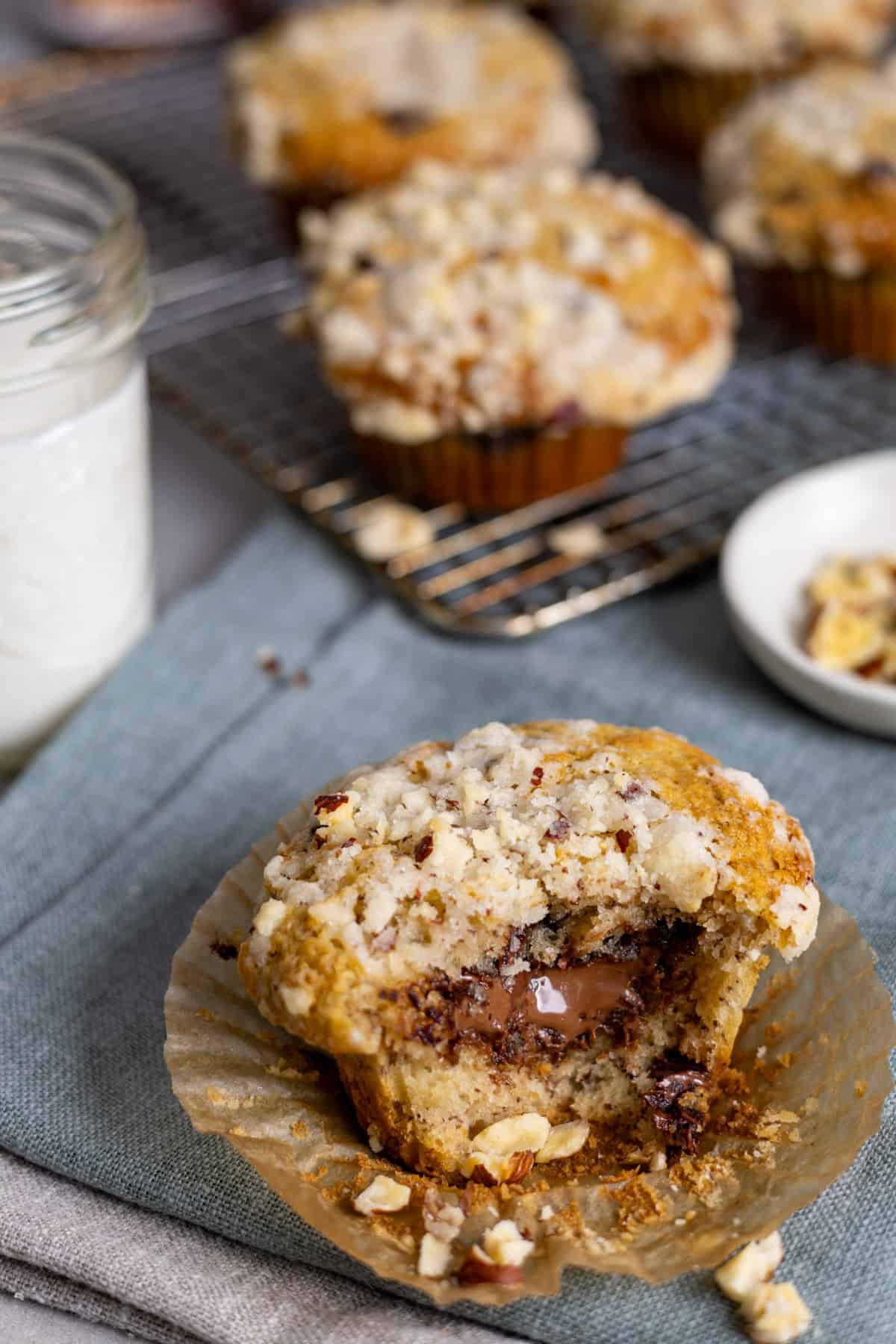 A nutella stuffed muffin with banana on a napkin on a gray table with more muffins in the background.