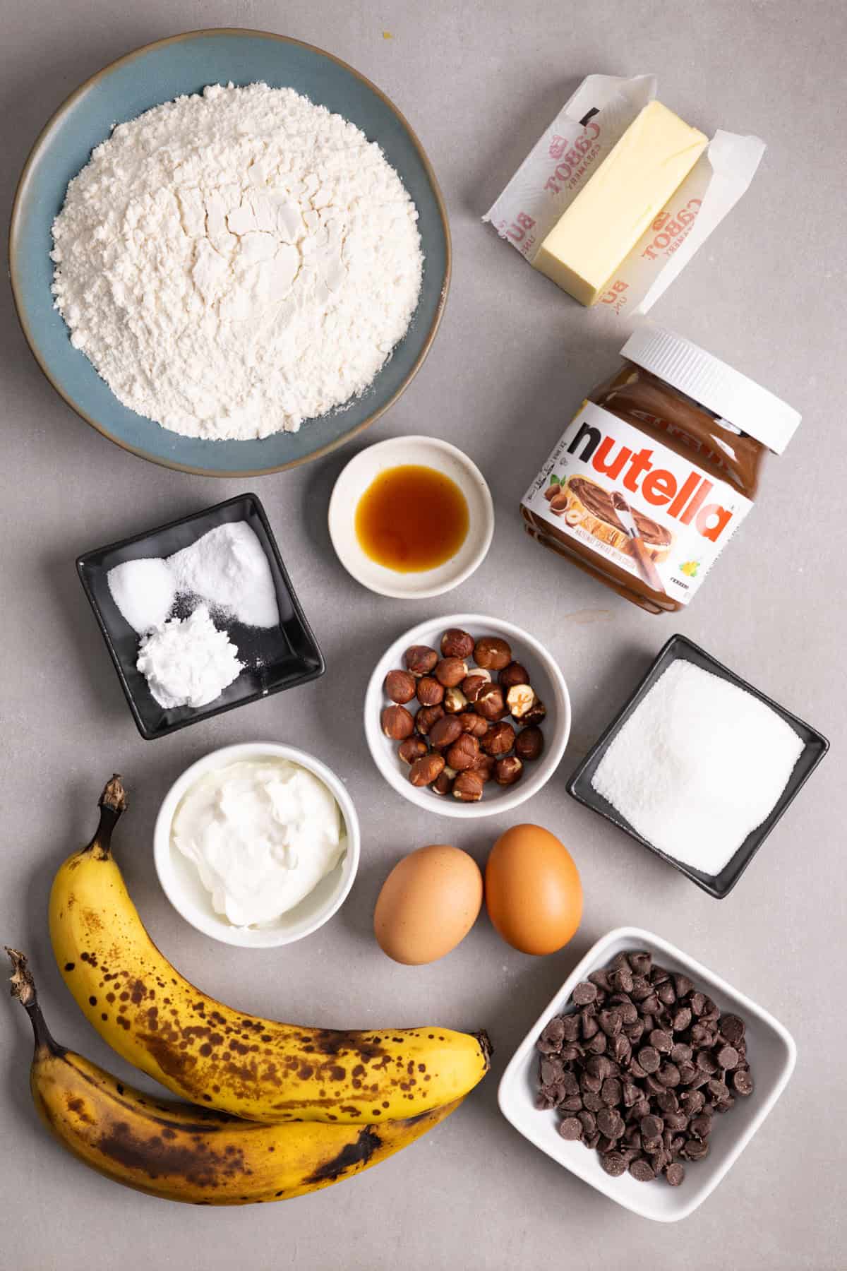 Ingredients for Nutella stuffed banana muffins on a gray table.