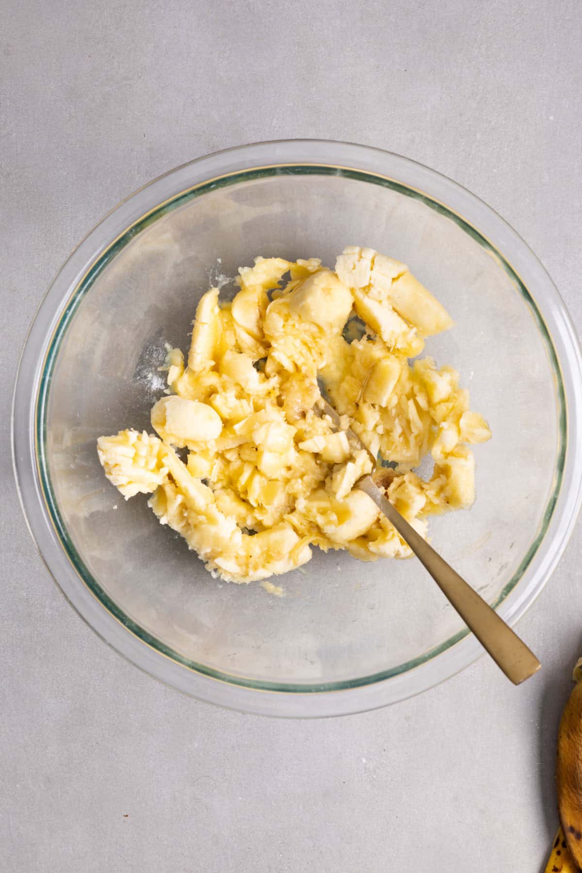 Banana mashed in a large mixing bowl.