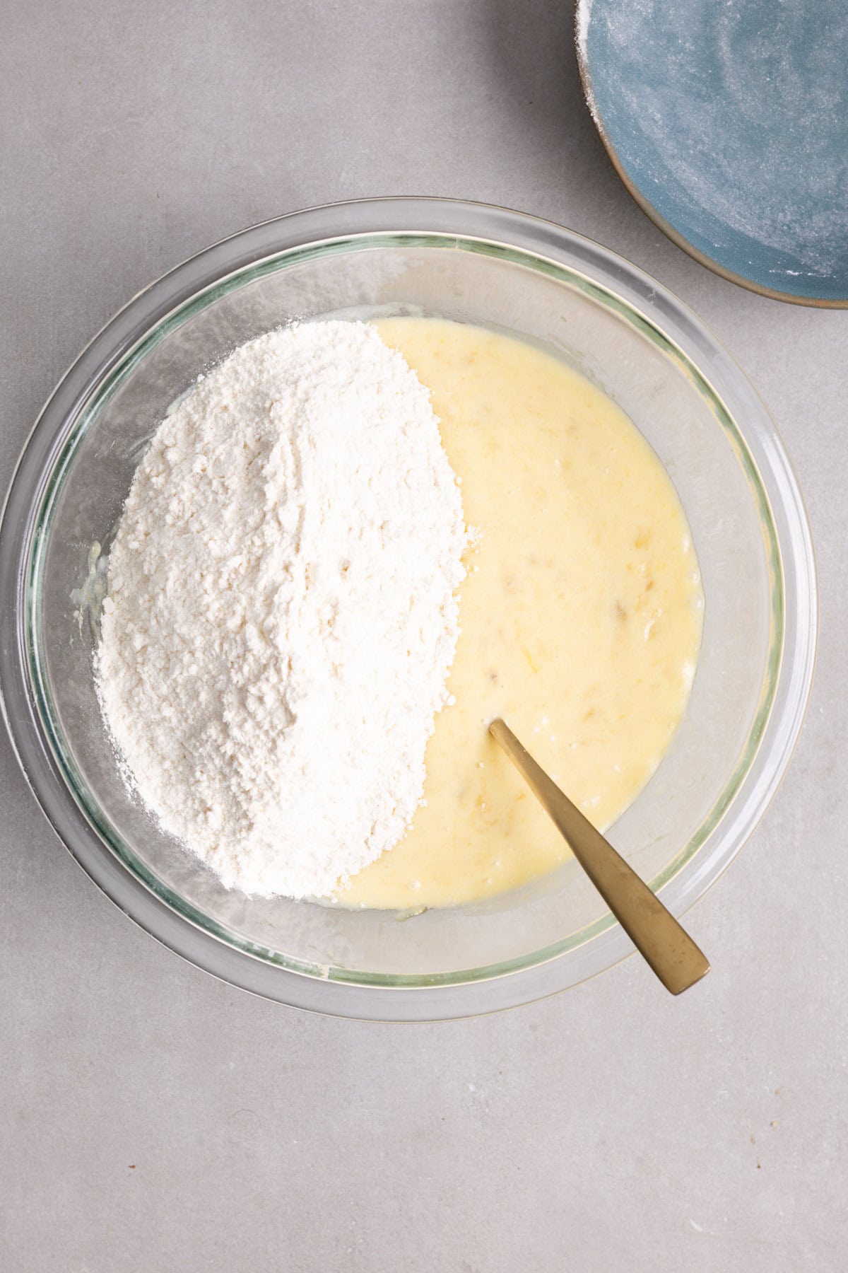 Dry ingredients getting stirred into wet ingredients for muffin batter.