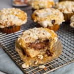 A nutella stuffed muffin on a napkin with a bite taken out and more muffins in the background.