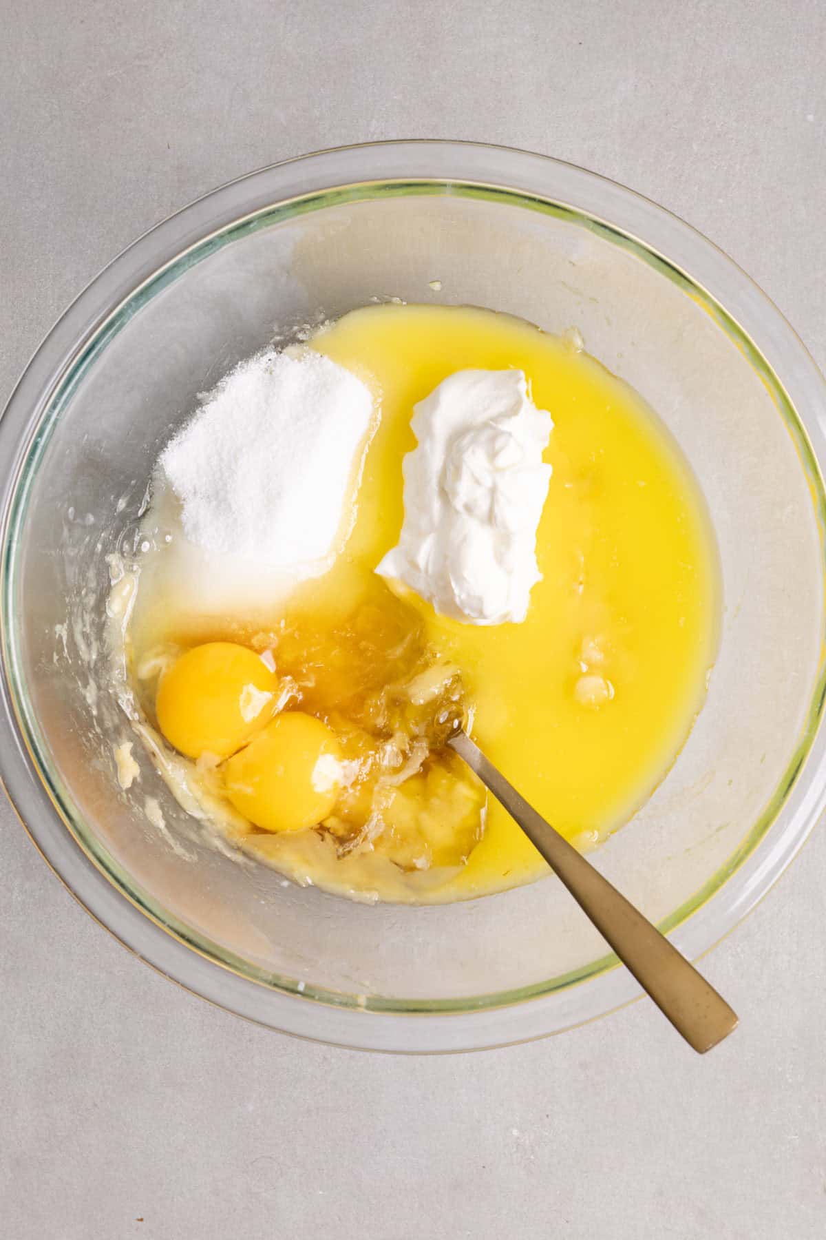 Wet ingredients for muffins in a large mixing bowl getting stirred together.