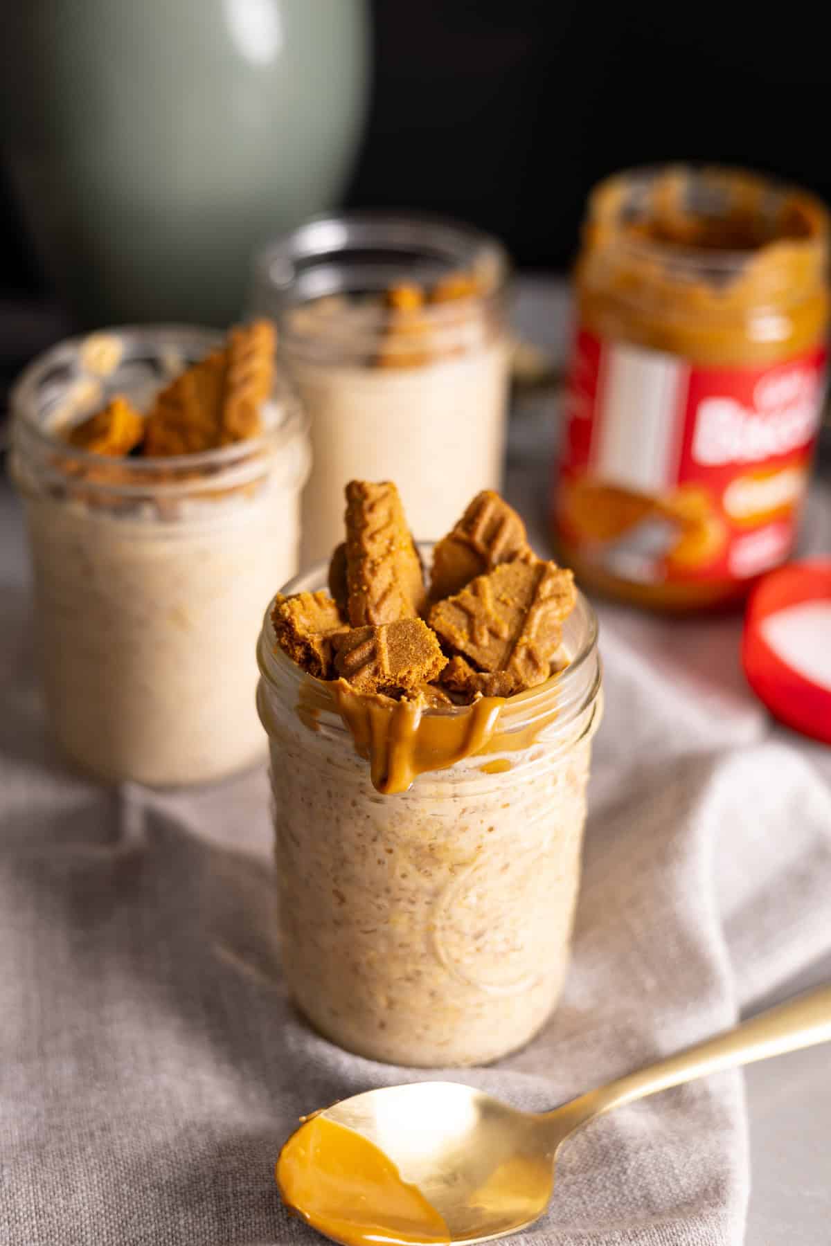Mason jars with biscoff cookie butter overnight oats on a gray table.