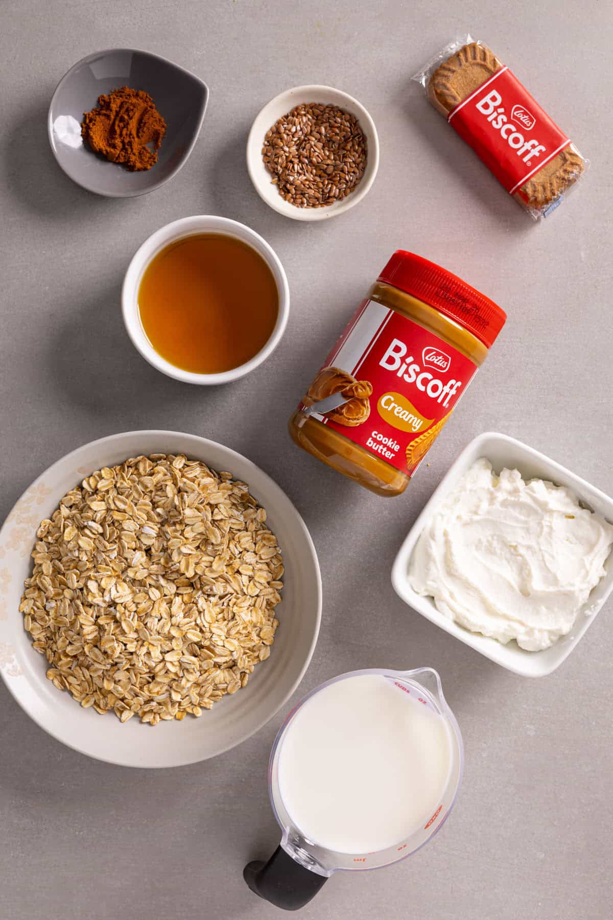 Ingredients for Lotus Biscoff overnight oats on a gray table.