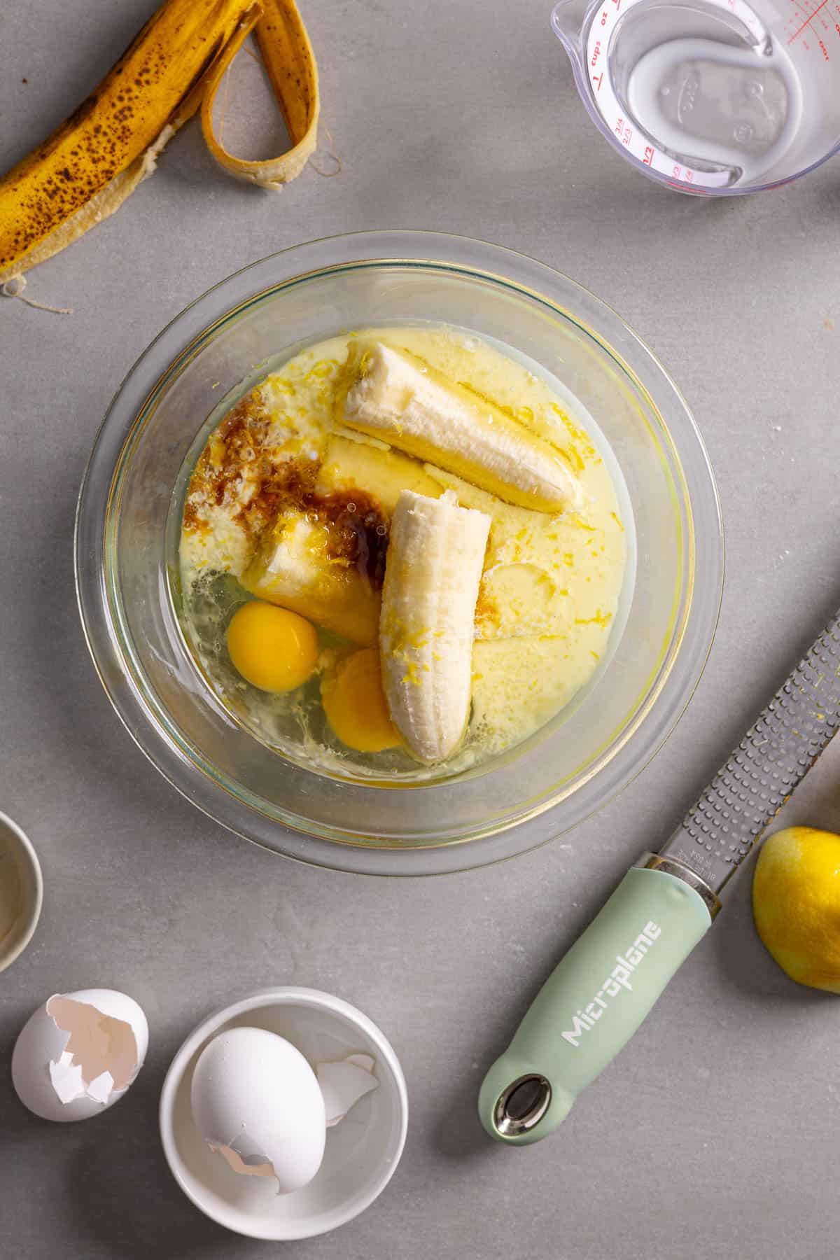 Banana and other wet ingredients for muffins in a medium bowl.