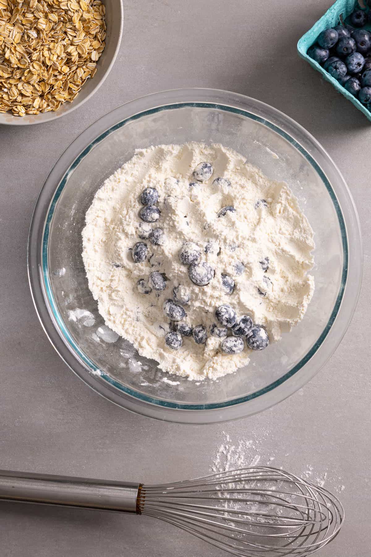 Blueberries tossed in a bowl with flour.