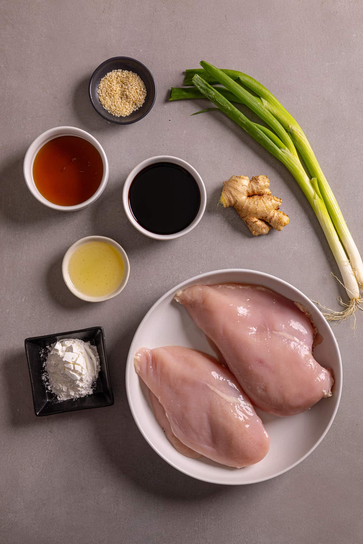 Ingredients for honey ginger chicken on a gray table.