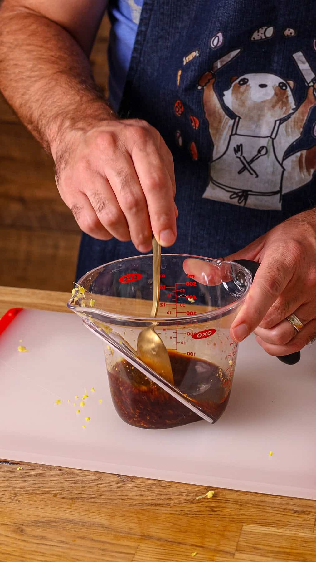 A ginger honey soy mixture getting stirred in a measuring cup.