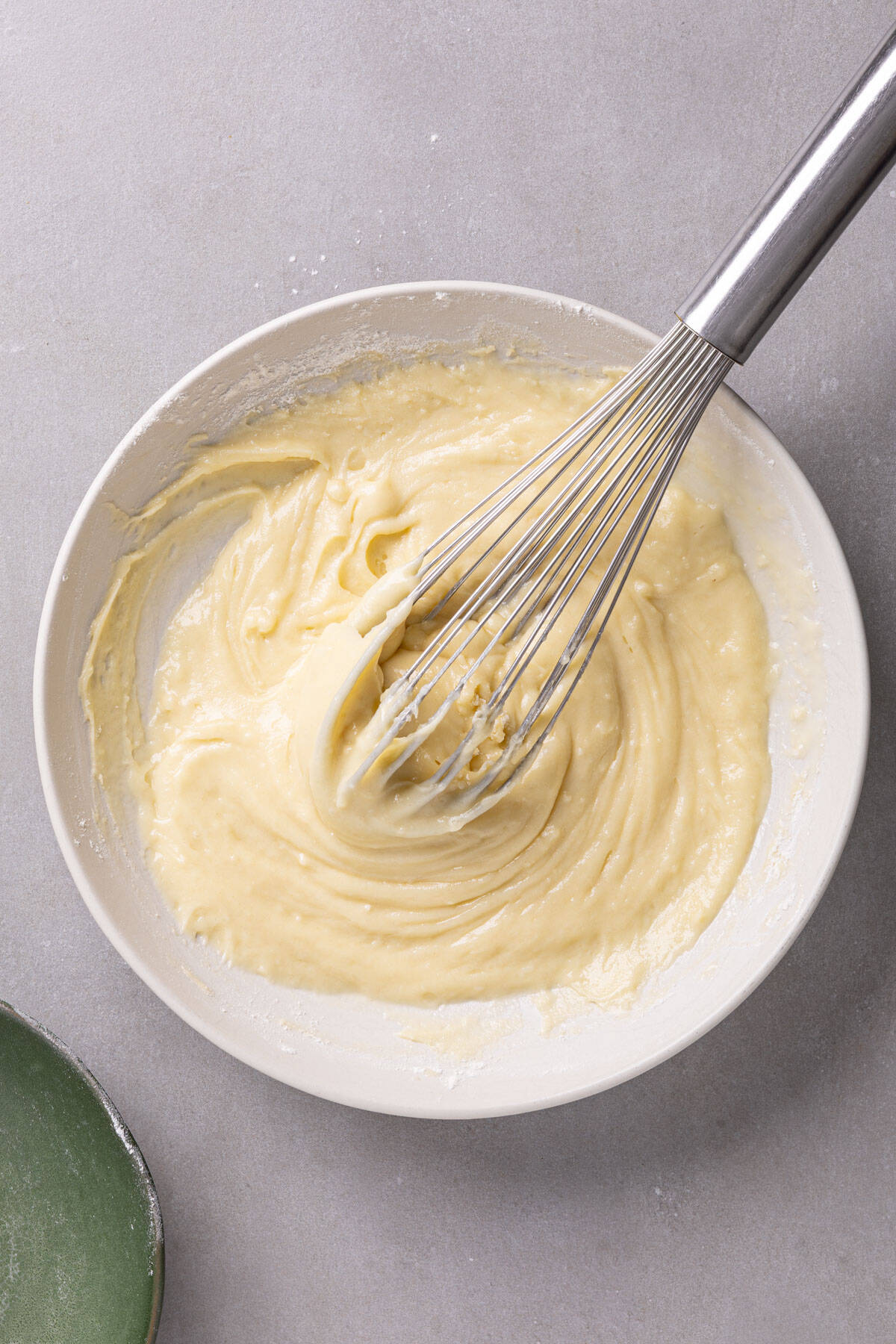 Polish style yogurt cake batter whisked in a white bowl.
