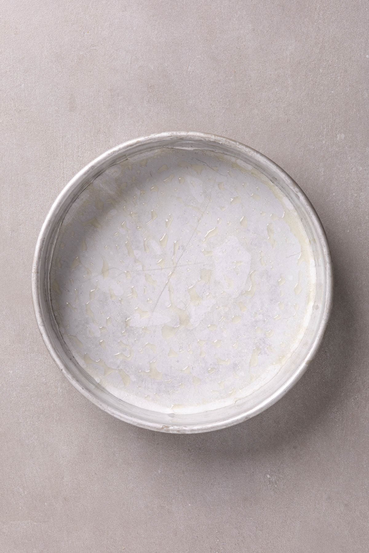 A round cake pan lined with parchment and cooking spray.