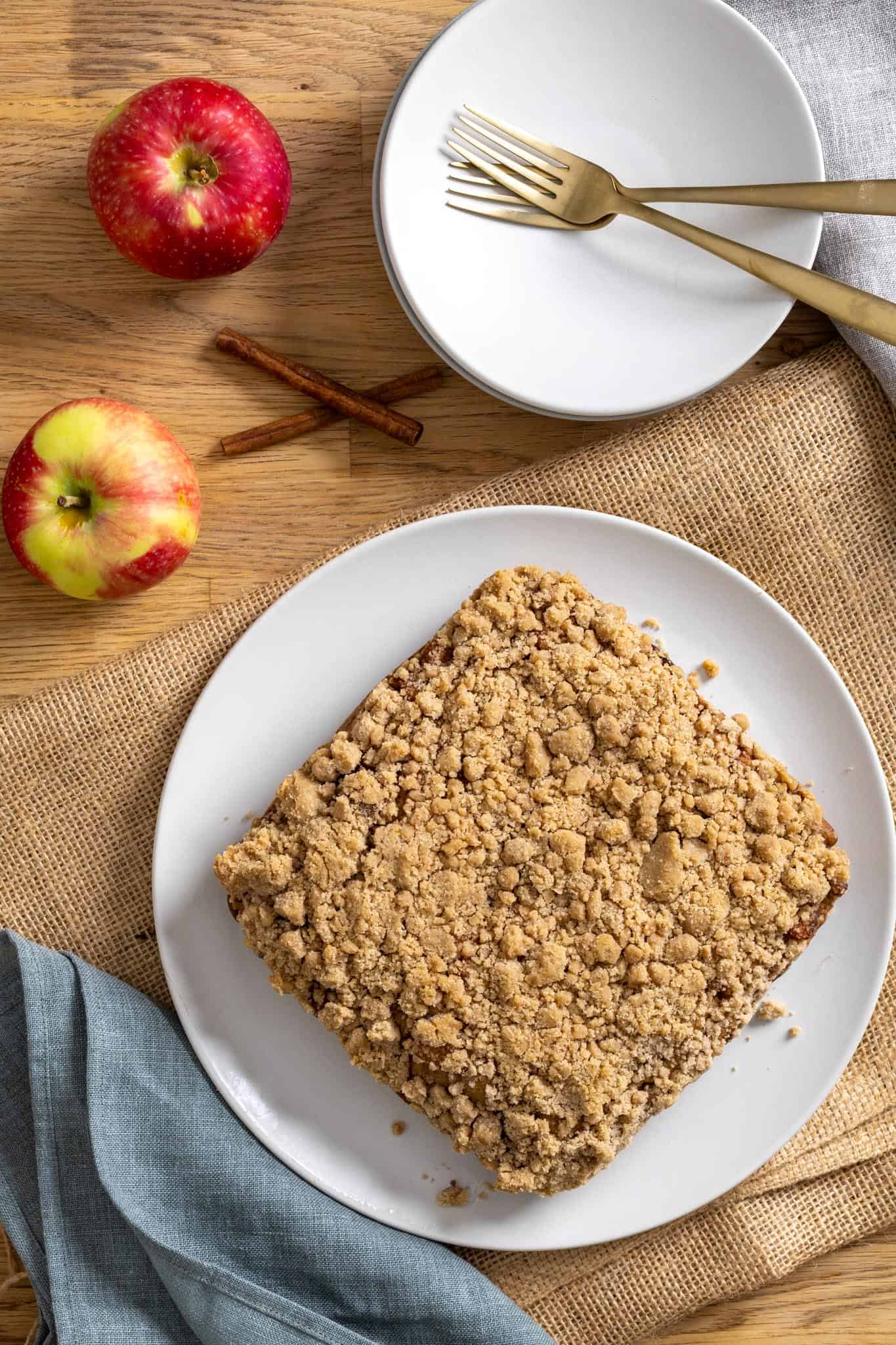 Applesauce coffee cake on a plate on a butcherblock countertop. 