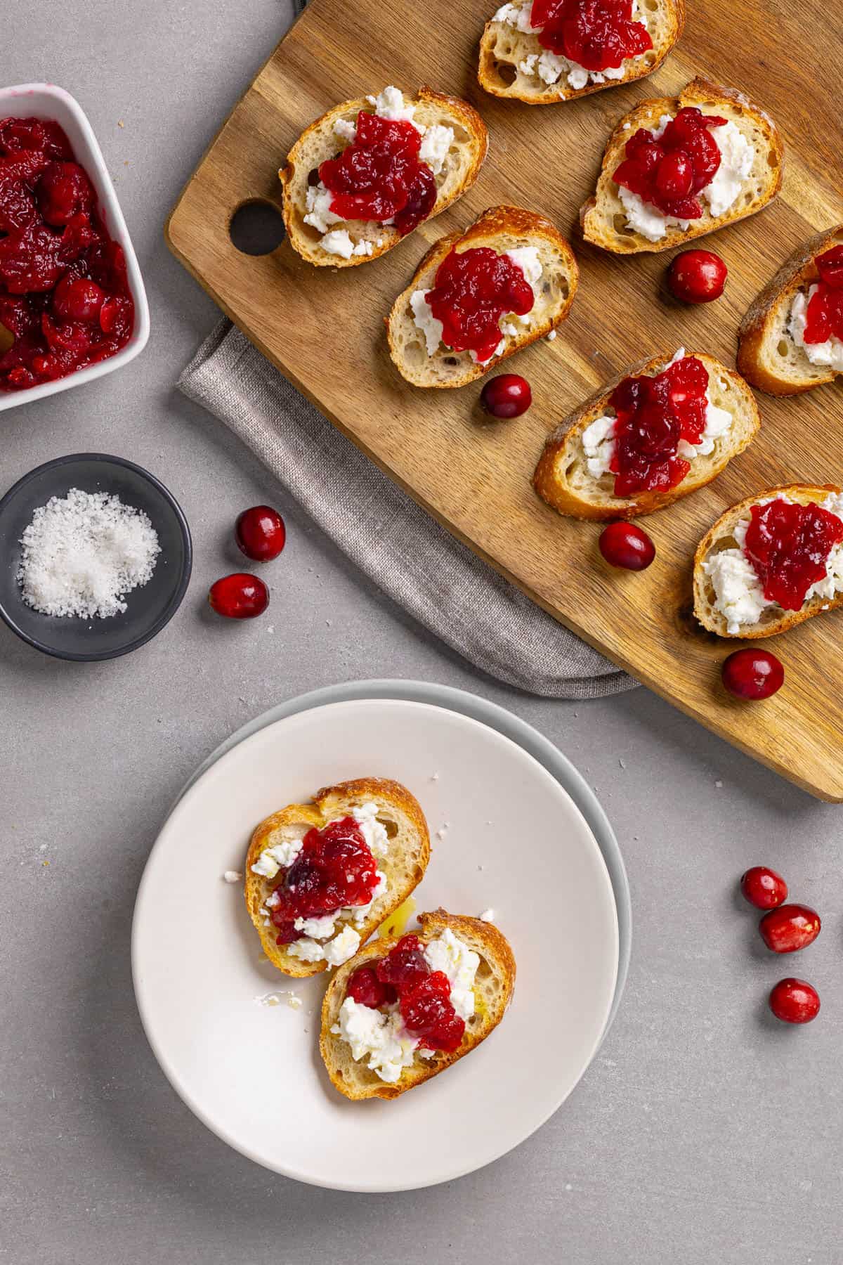 A platter and small plate with cranberry goat cheese crostini.