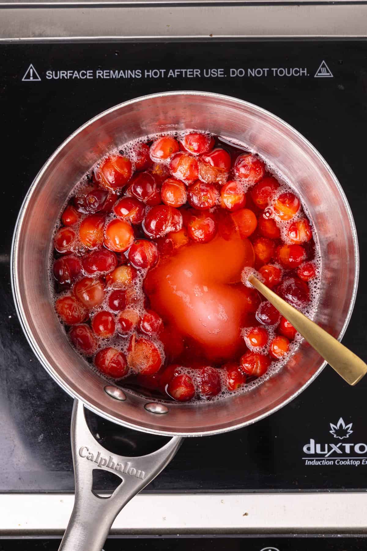 A small saucepan with burst fresh cranberries, water and granulated sugar for a simple syrup.