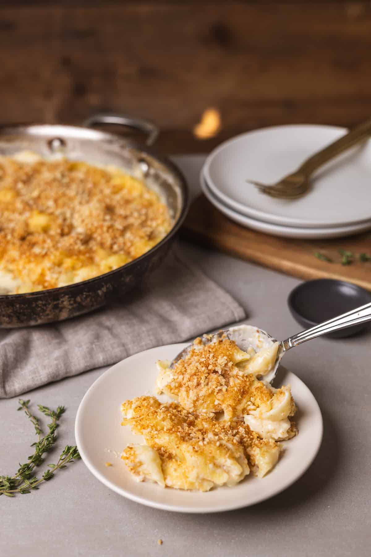 A close up of gouda mac and cheese getting served on a small plate.