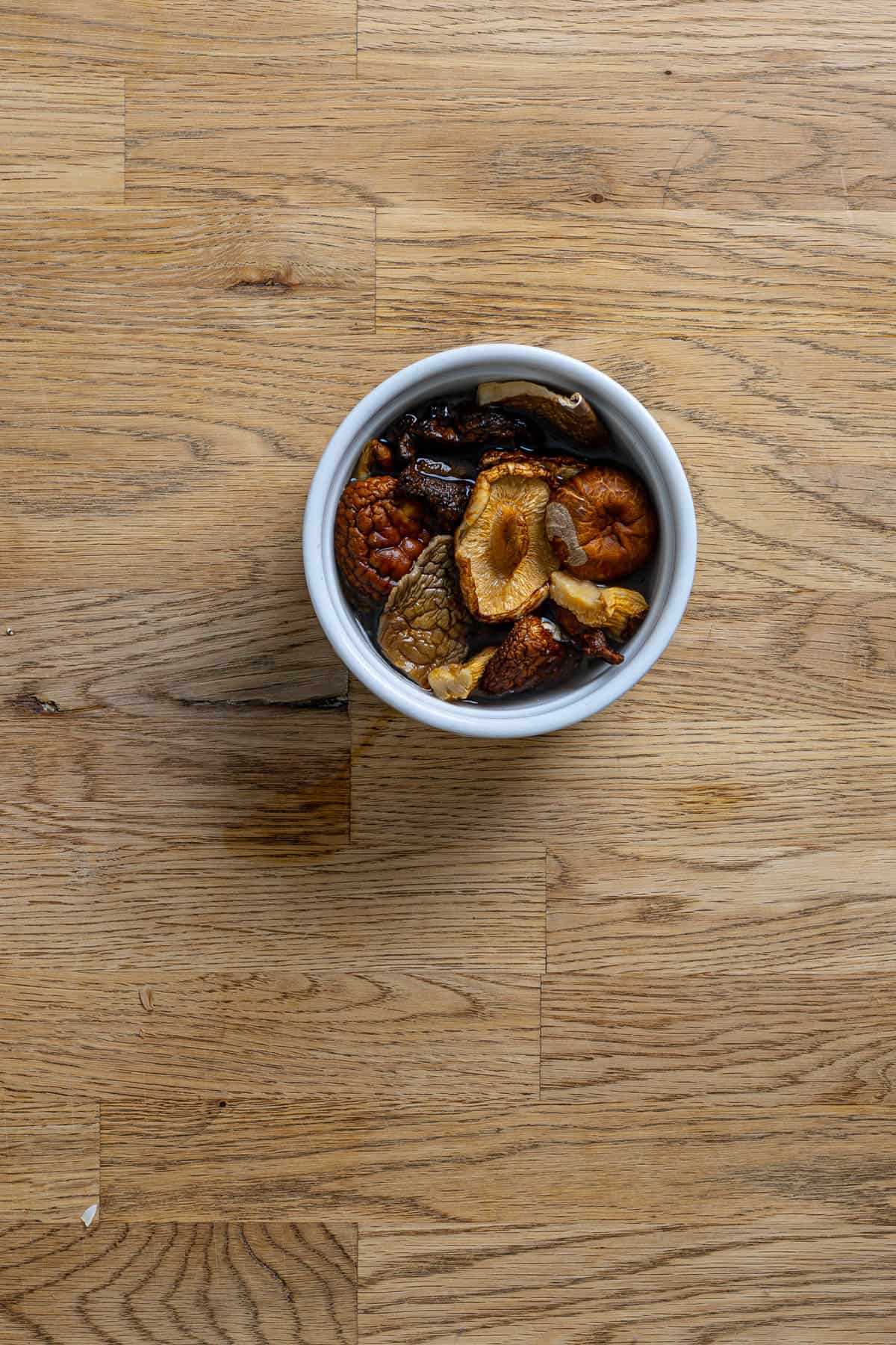 A small bowl with dried mushrooms covered in warm water.