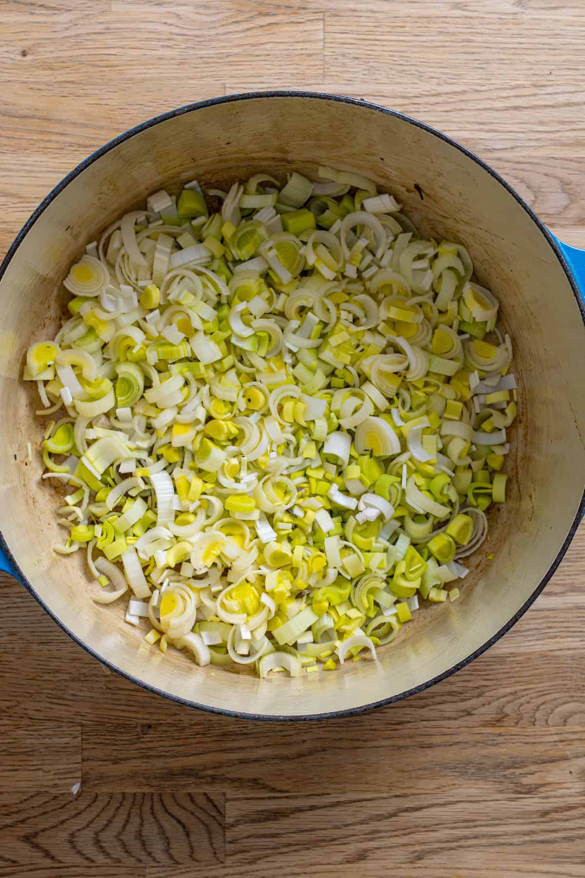 Chopped leeks cooking in a dutch oven.