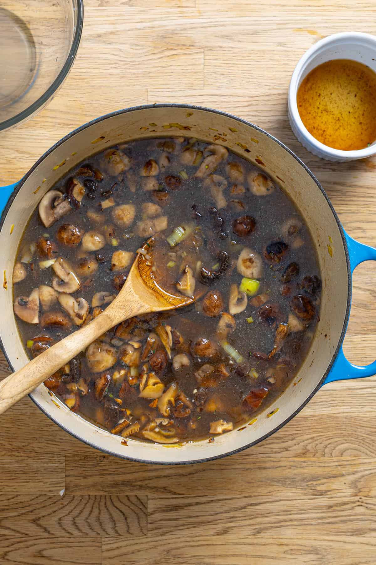 A pot of mushroom and leek soup cooking.