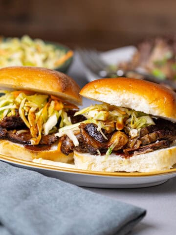 Two braised beef sliders topped with citrus slaw.