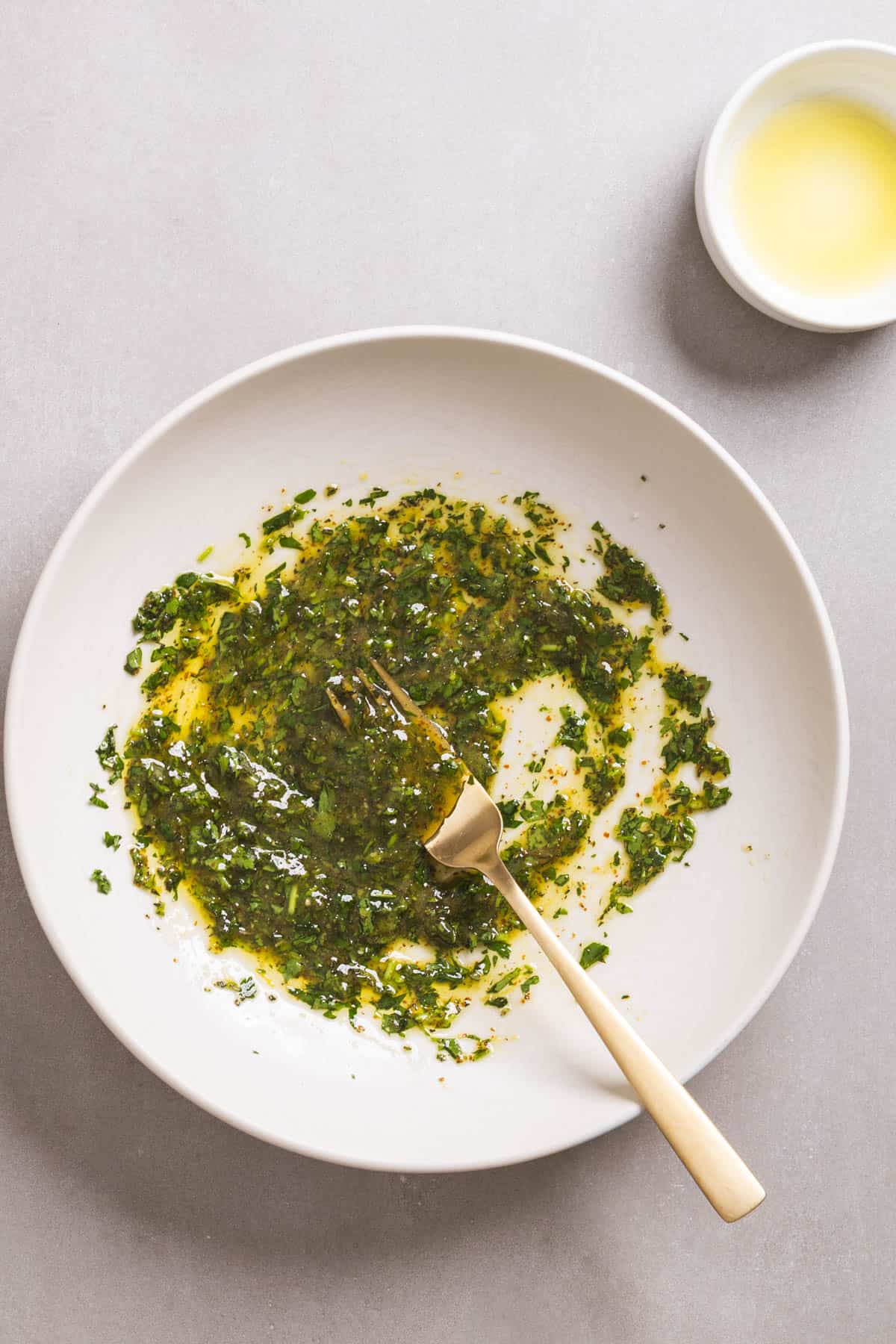 A large mixing bowl with an herb and lemon chicken marinade.